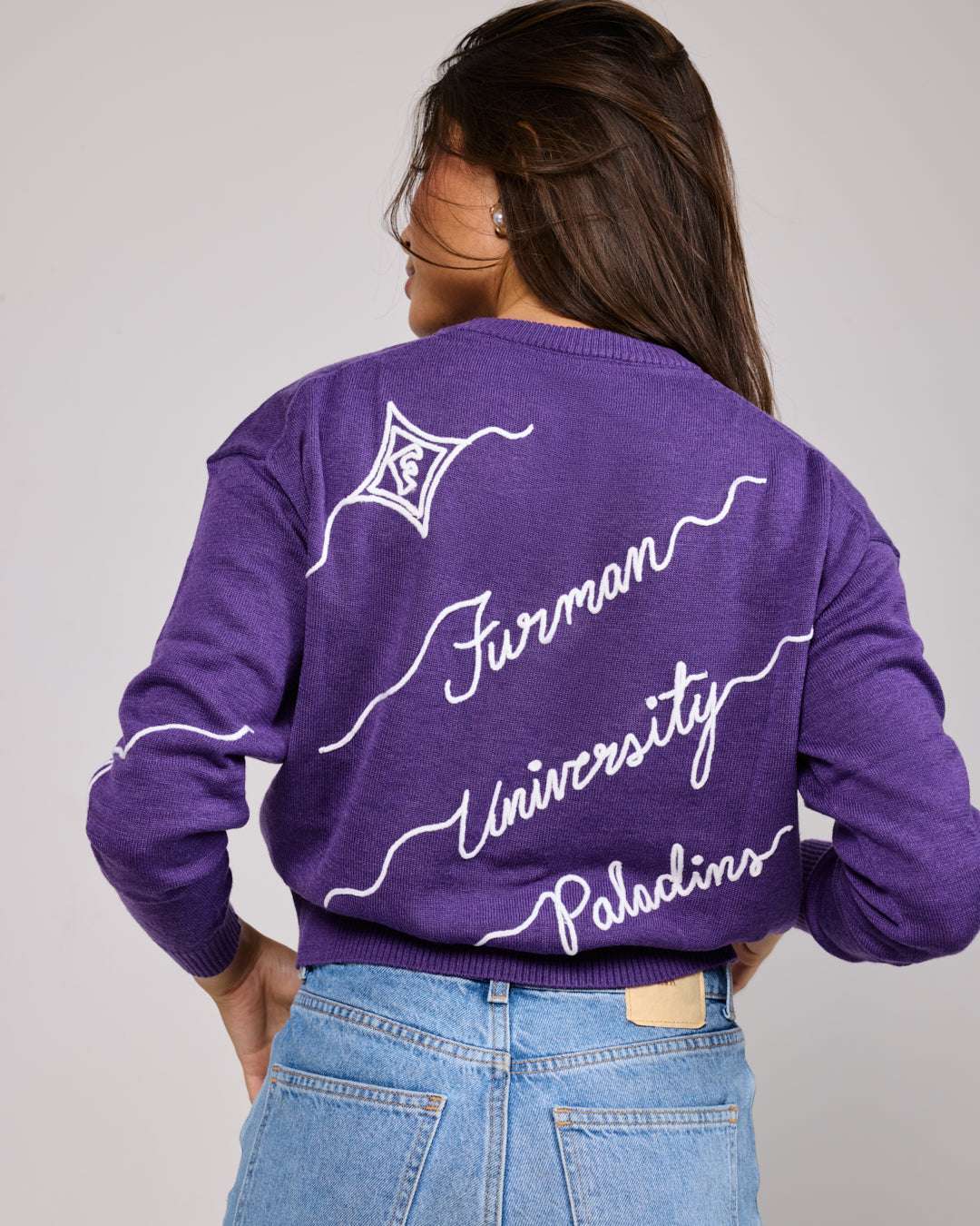 purple crewneck sweater with furman university paladins embroidery, styled for college game day