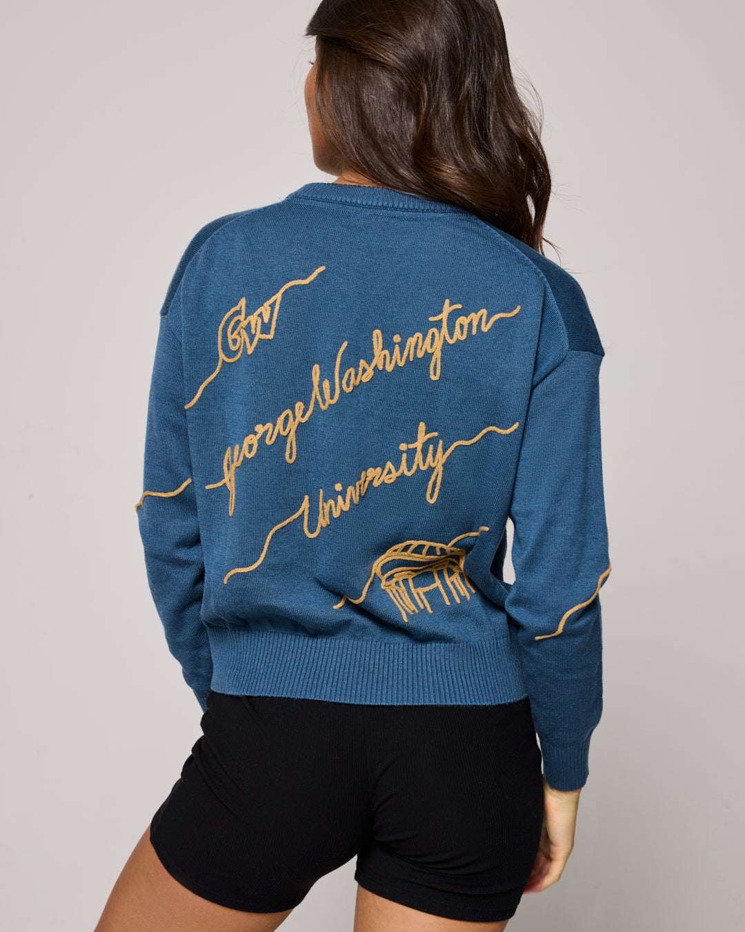 blue crewneck sweater with george washington university embroidery, styled for college tailgates