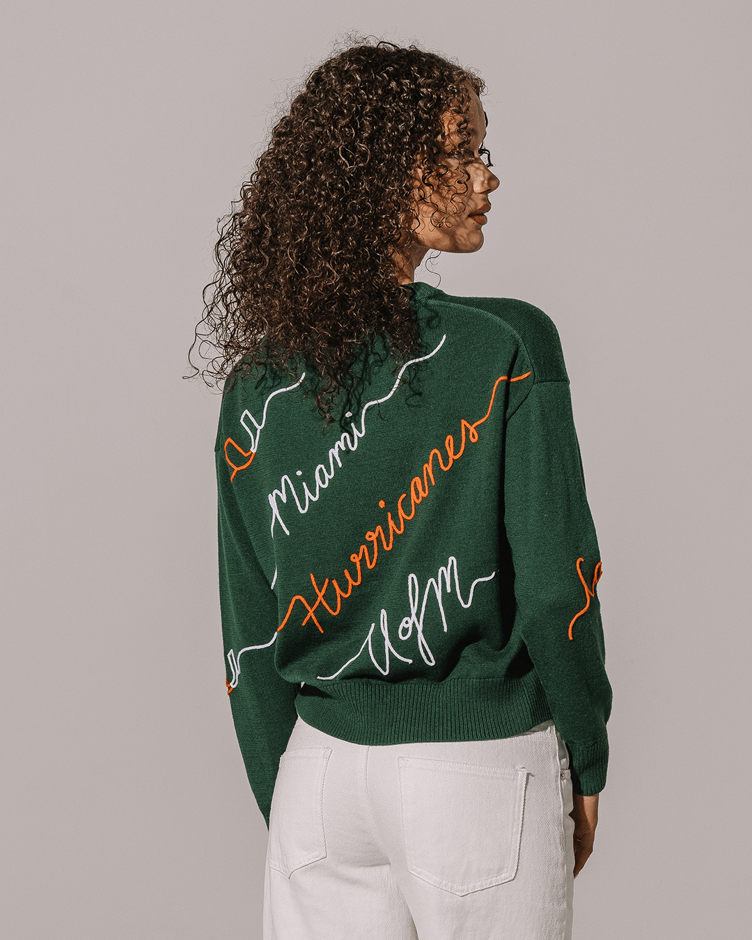 green crewneck sweater with umiami hurricanes embroidery, perfect for college game days.