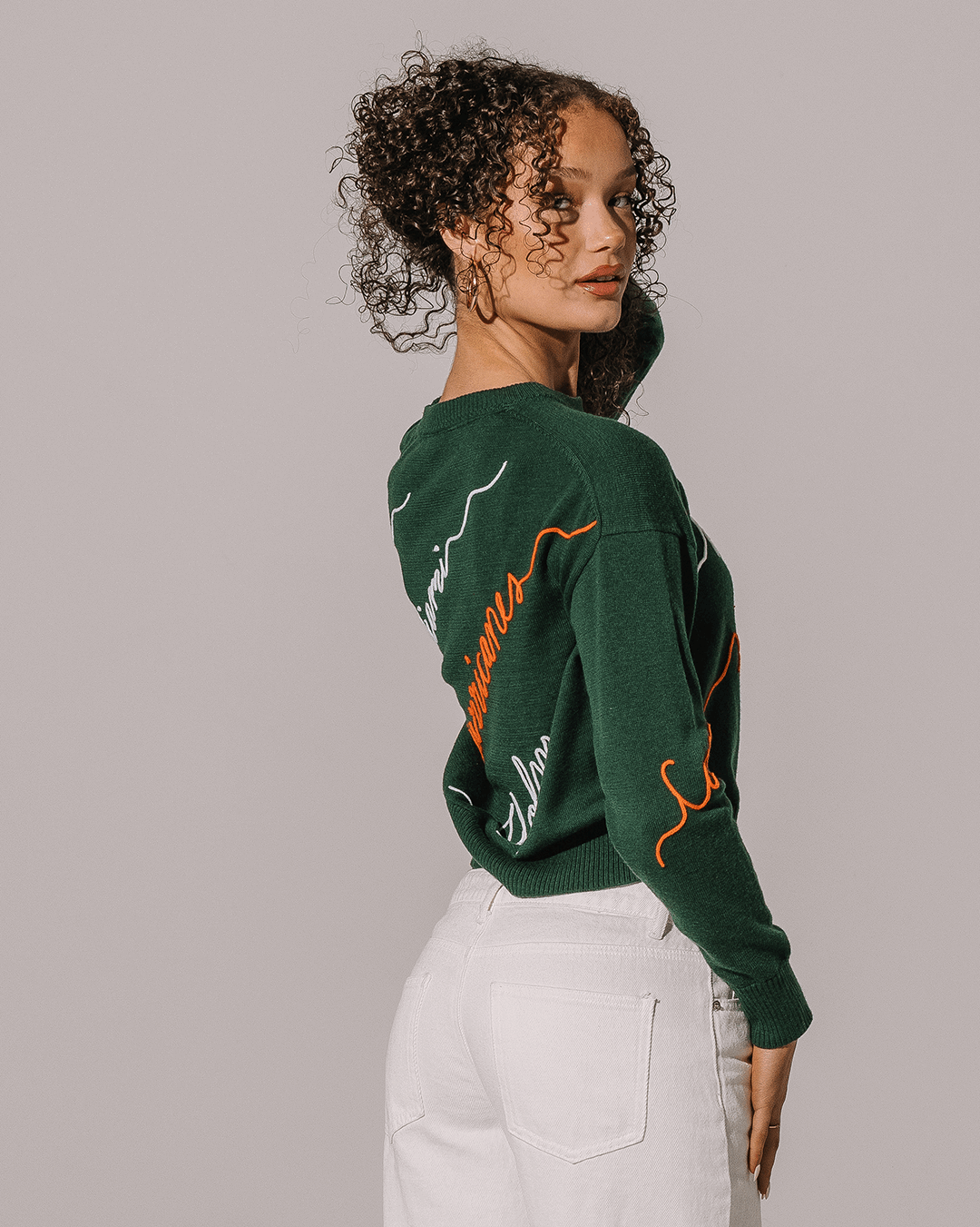 green crewneck sweater with umiami hurricanes embroidery, perfect for college game days.