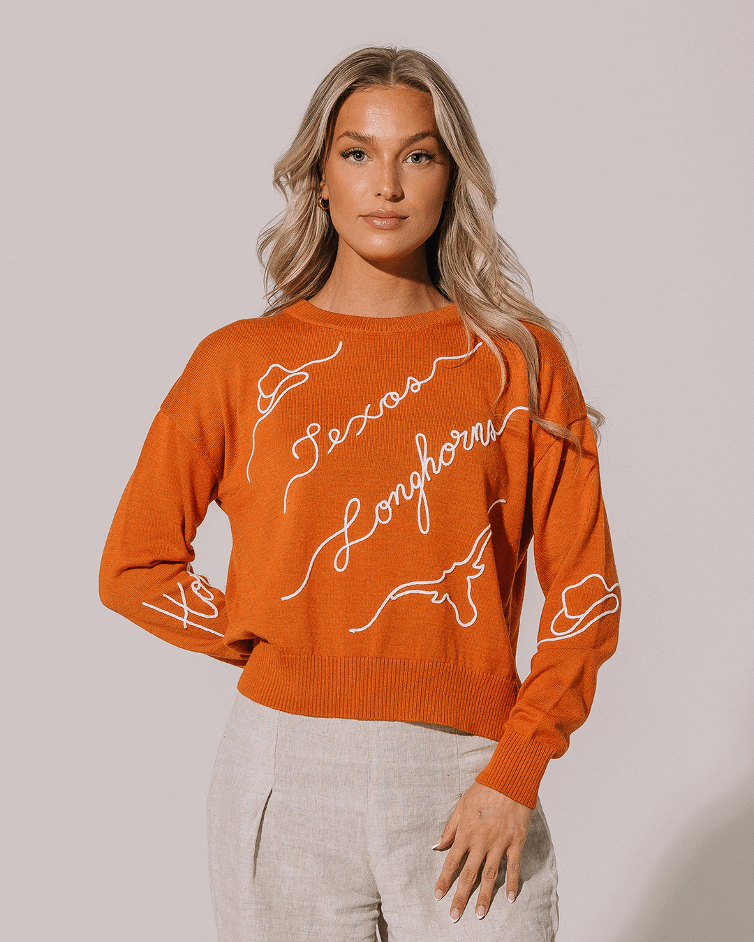 orange long sleeve sweater with texas longhorns embroidery, designed for college tailgate outfits.