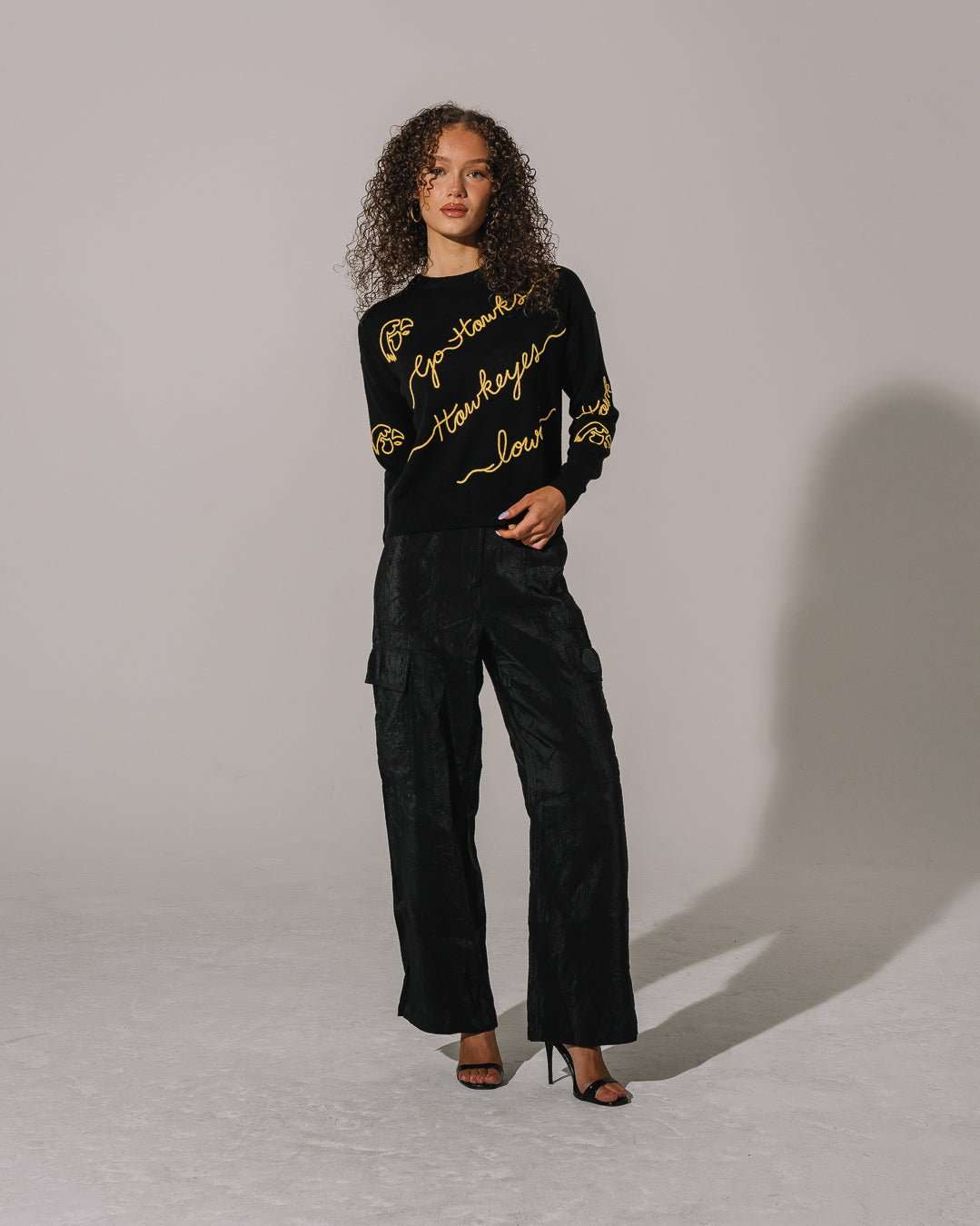 black crewneck sweater with iowa hawkeyes embroidery, styled for back to school