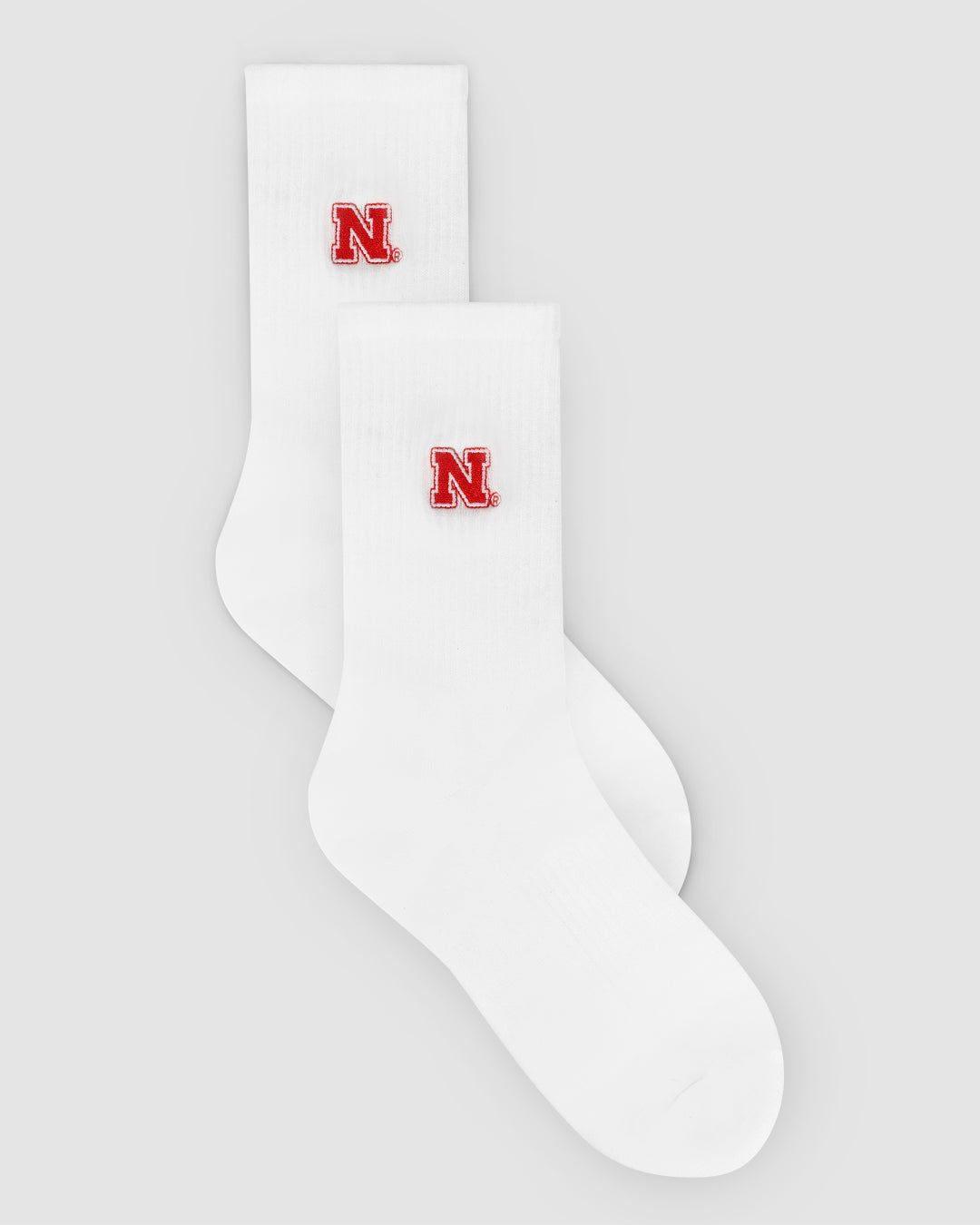 White crew sock with Nebraska Cornhuskers patch, perfect for campus and lounging