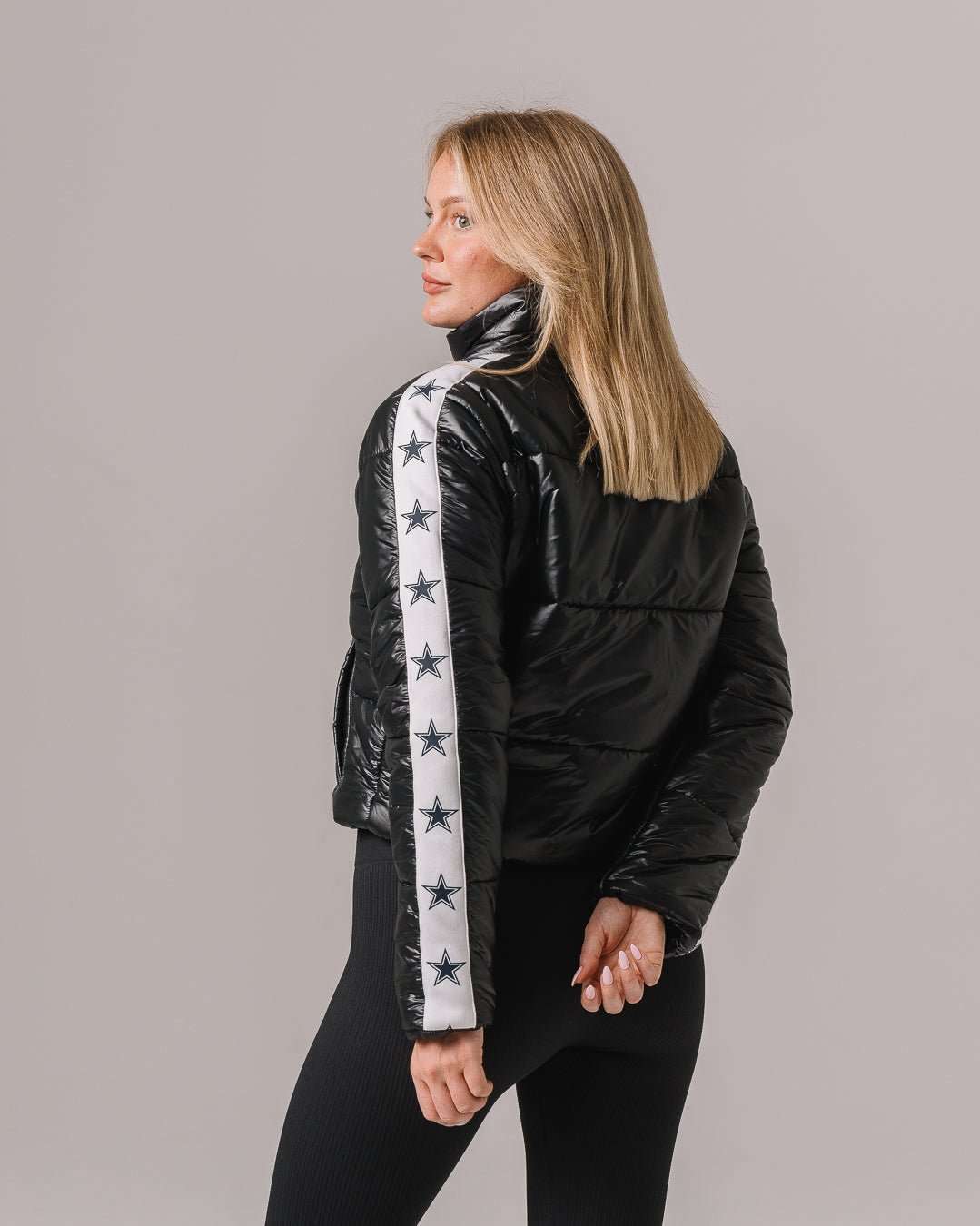 Black cargo puffer featuring Dallas Cowboys insignia, styled for tailgates, game day, or casual wear.