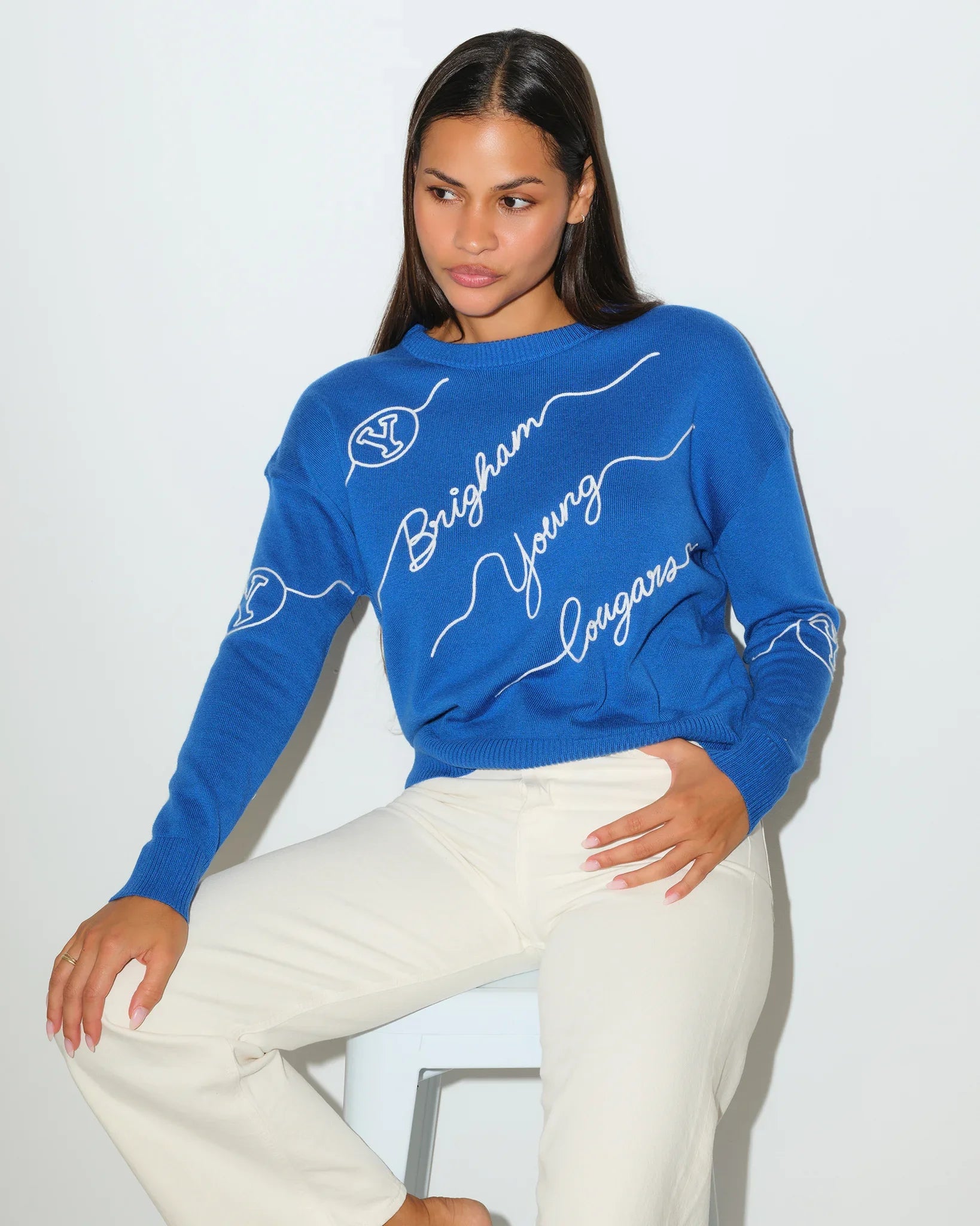 Royal blue BYU Cougars crewneck sweater featuring cursive "Brigham Young" script lettering across the front with a small BYU logo on the sleeve.