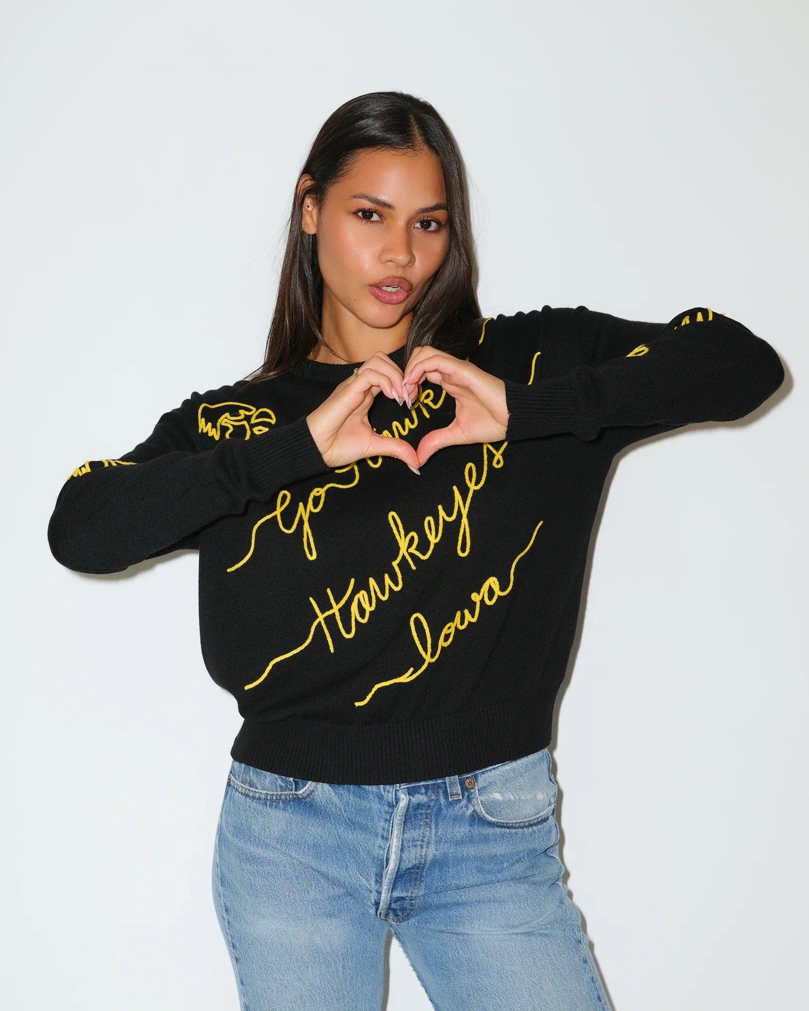 Black Iowa Hawkeyes crewneck sweater featuring gold script "Hawkeyes," "Iowa," and "Go Hawks" lettering with decorative accents throughout.
