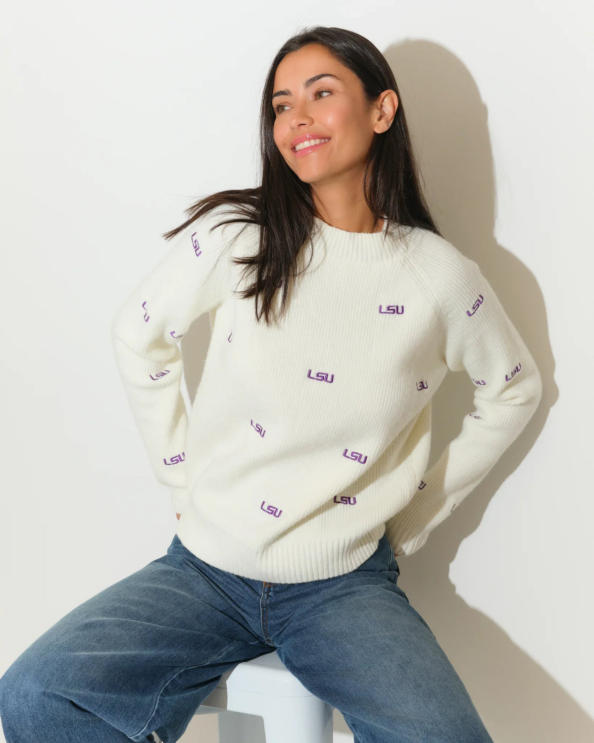 Ivory LSU Tigers fisherman sweater featuring repeated purple "LSU" embroidery throughout, shown on a model with a relaxed crewneck fit.