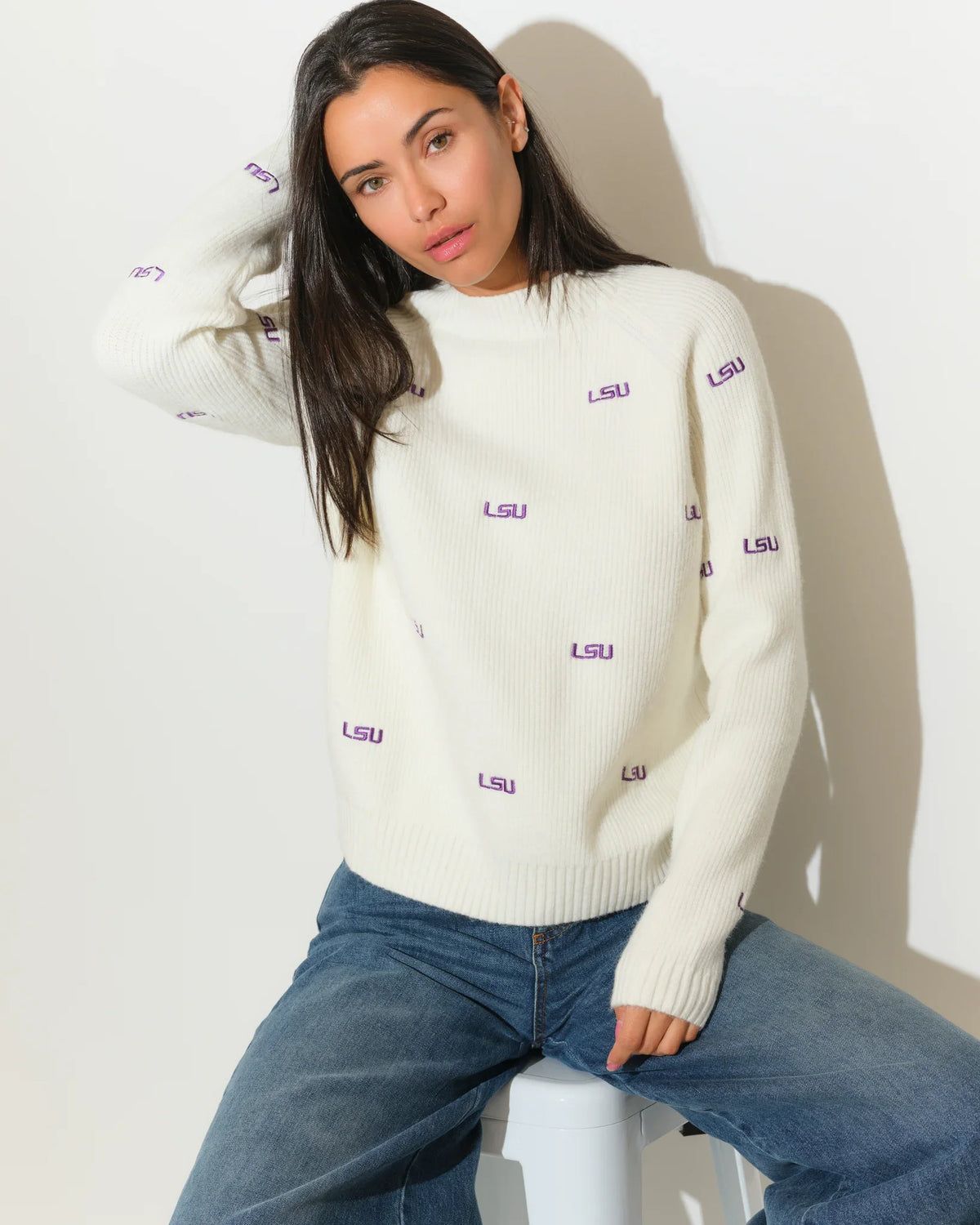 Ivory LSU Tigers fisherman sweater featuring repeated purple "LSU" embroidery throughout, shown on a model with a relaxed crewneck fit.