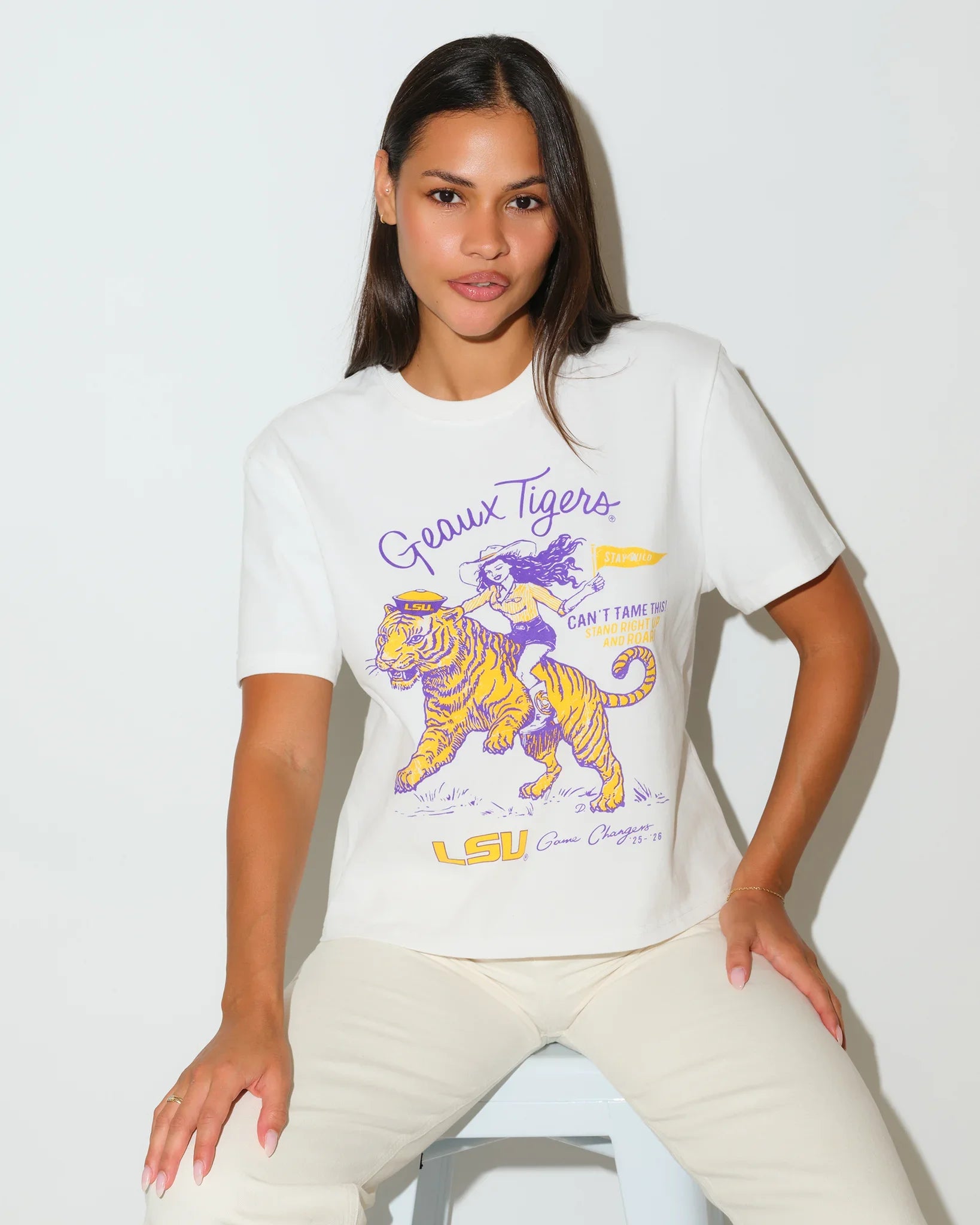 White LSU Tigers Game Changer Tee featuring a graphic of a girl riding a tiger in purple and gold, with "Geaux Tigers" script lettering.