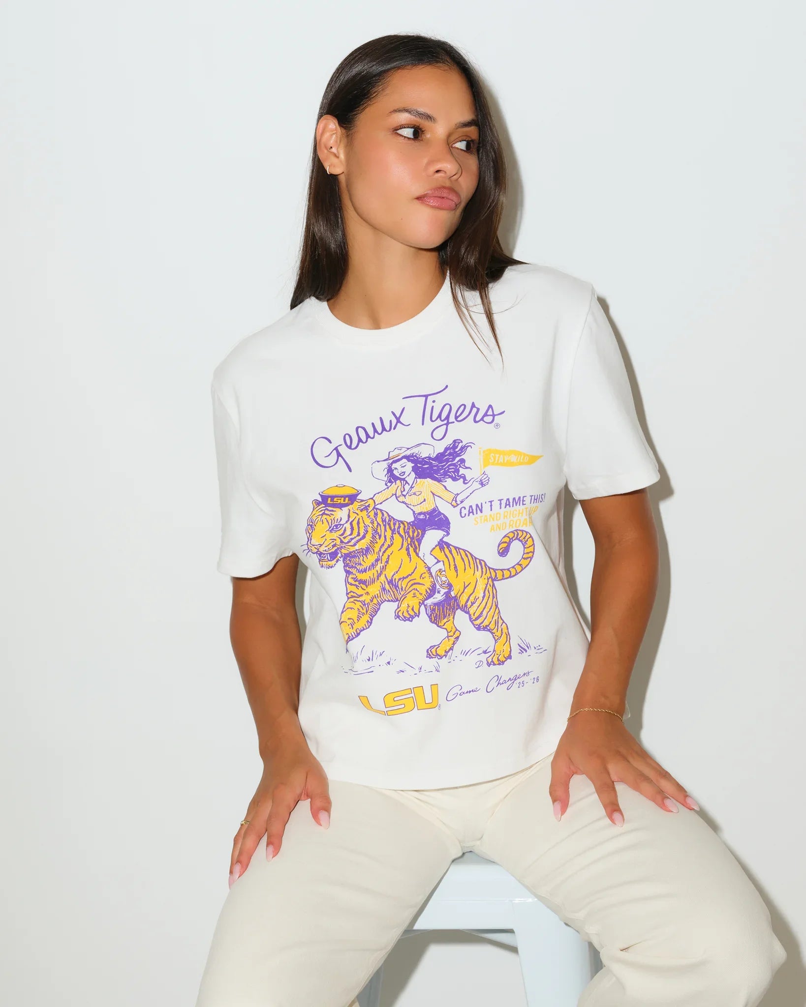 White LSU Tigers Game Changer Tee featuring a graphic of a girl riding a tiger in purple and gold, with "Geaux Tigers" script lettering.