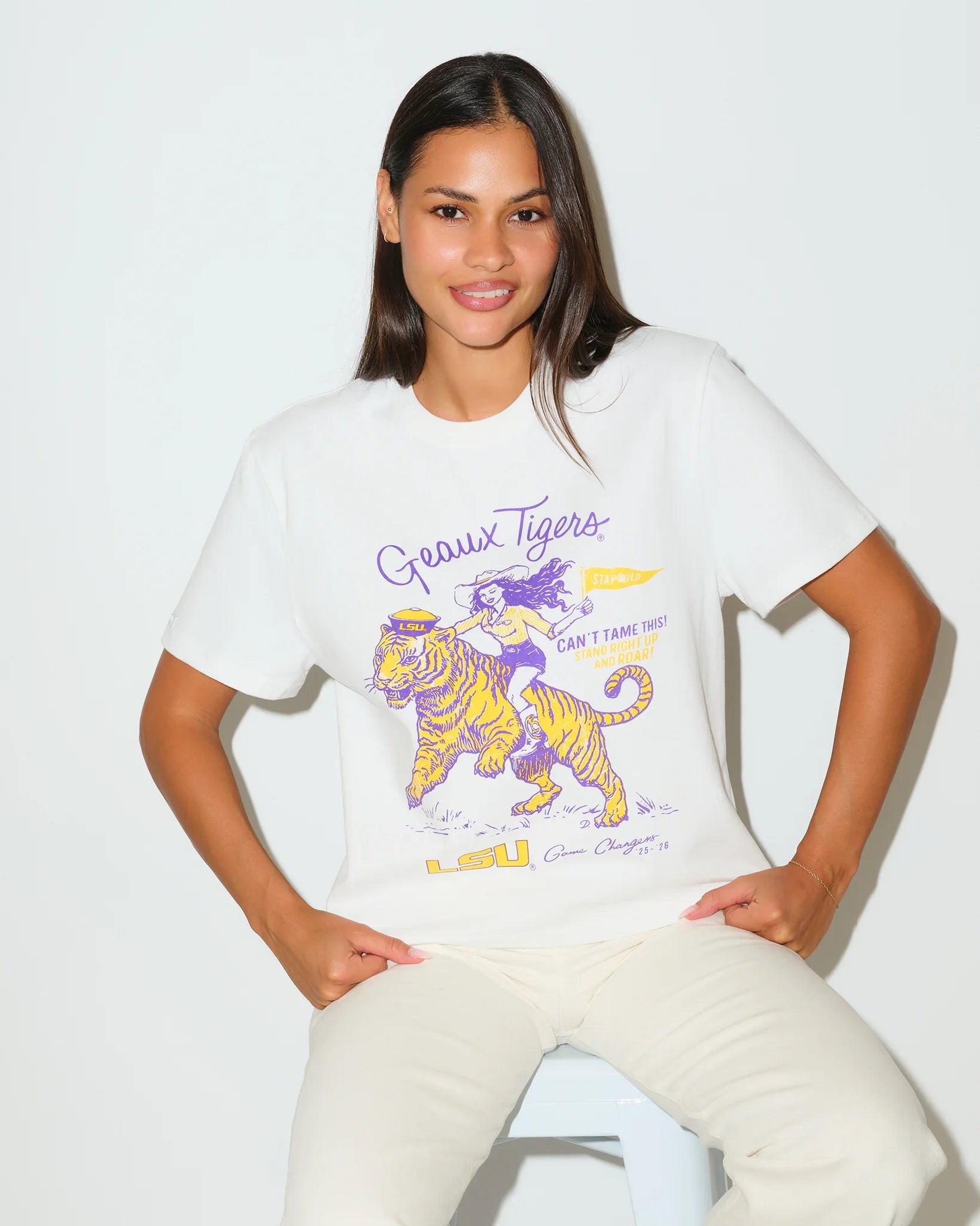 White LSU Tigers Game Changer Tee featuring a graphic of a girl riding a tiger in purple and gold, with "Geaux Tigers" script lettering.