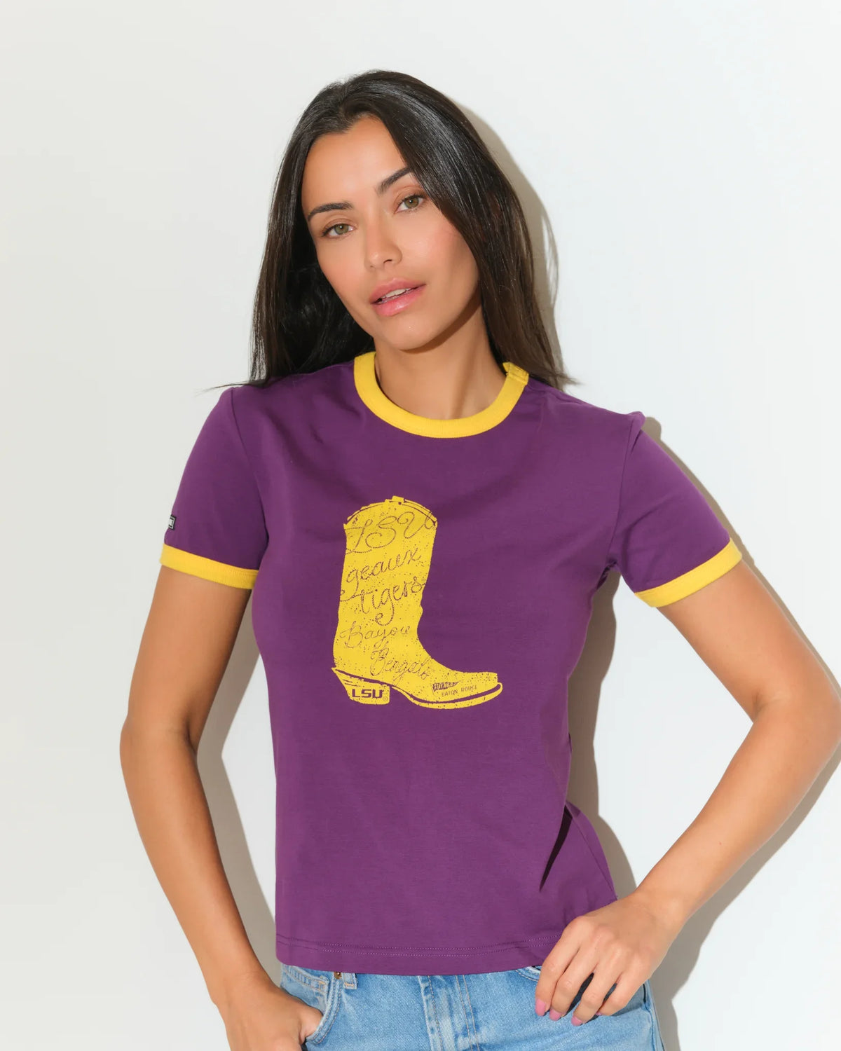 Purple LSU Tigers women's ringer tee with gold trim and a large embroidered-style gold cowboy boot graphic on the chest.