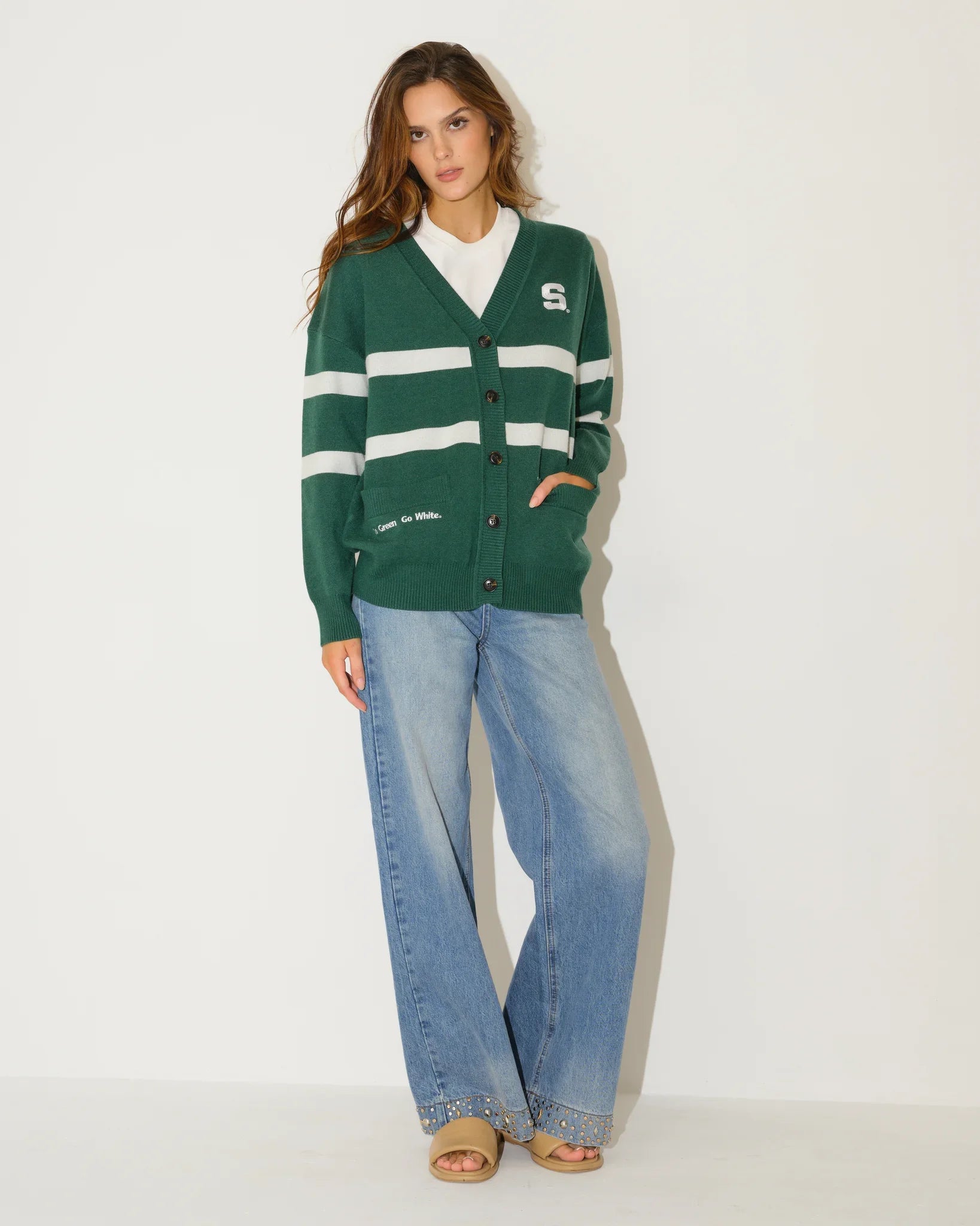 Evergreen Michigan State Spartans Vinti Cardi in a relaxed fit with script graphics and floral sleeve details, styled with denim shorts and boots.