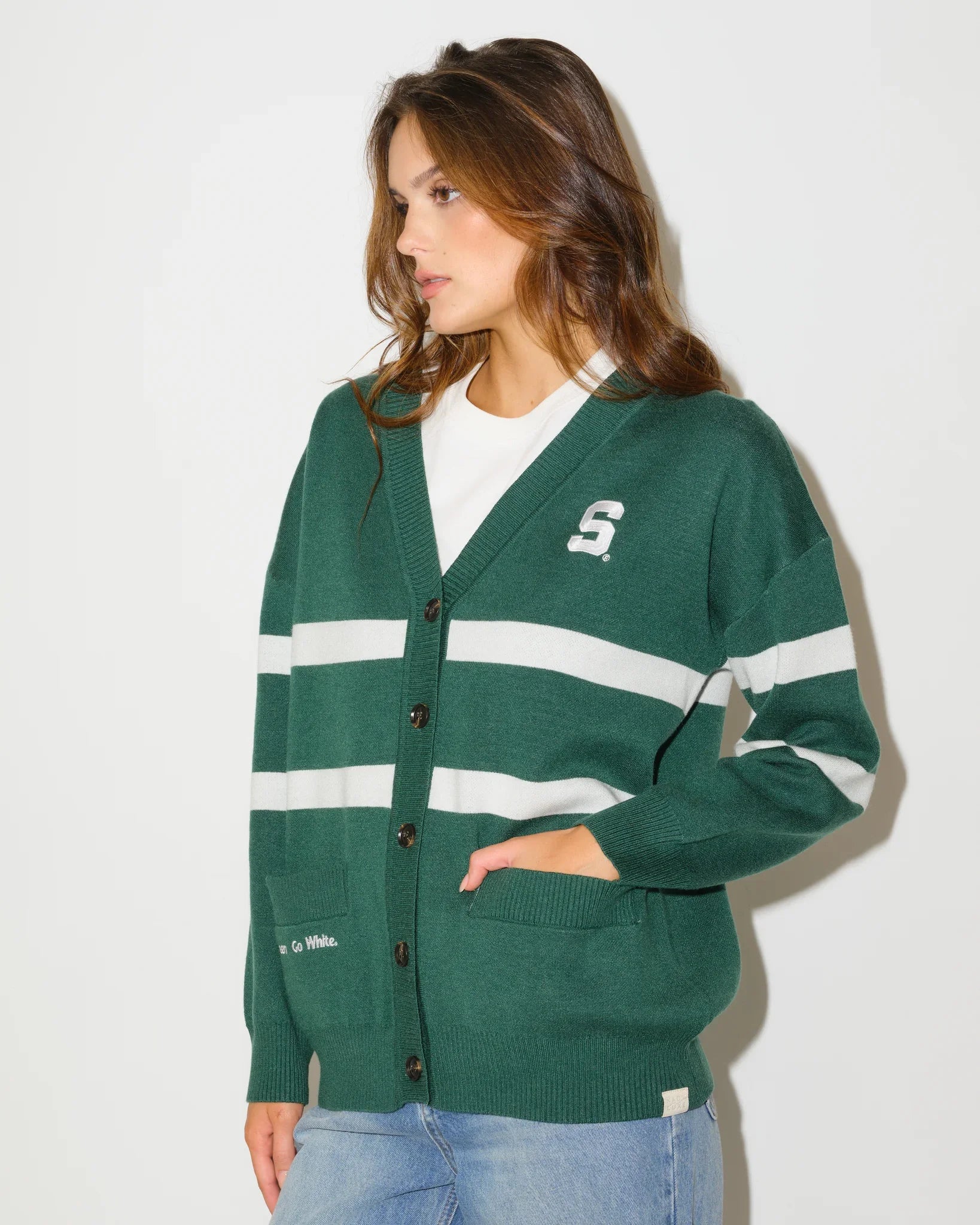Evergreen Michigan State Spartans Vinti Cardi in a relaxed fit with script graphics and floral sleeve details, styled with denim shorts and boots.