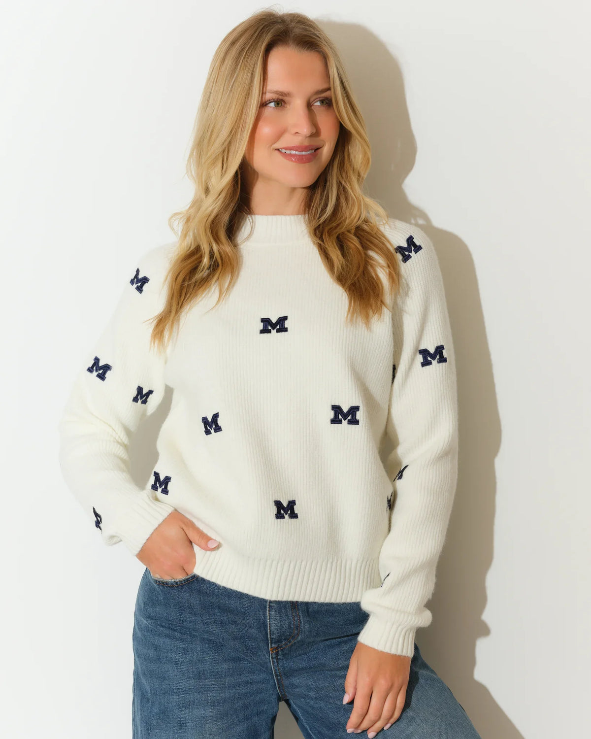 Ivory Michigan Wolverines fisherman sweater featuring an allover navy embroidered "M" logo pattern, with a relaxed crew neck silhouette.