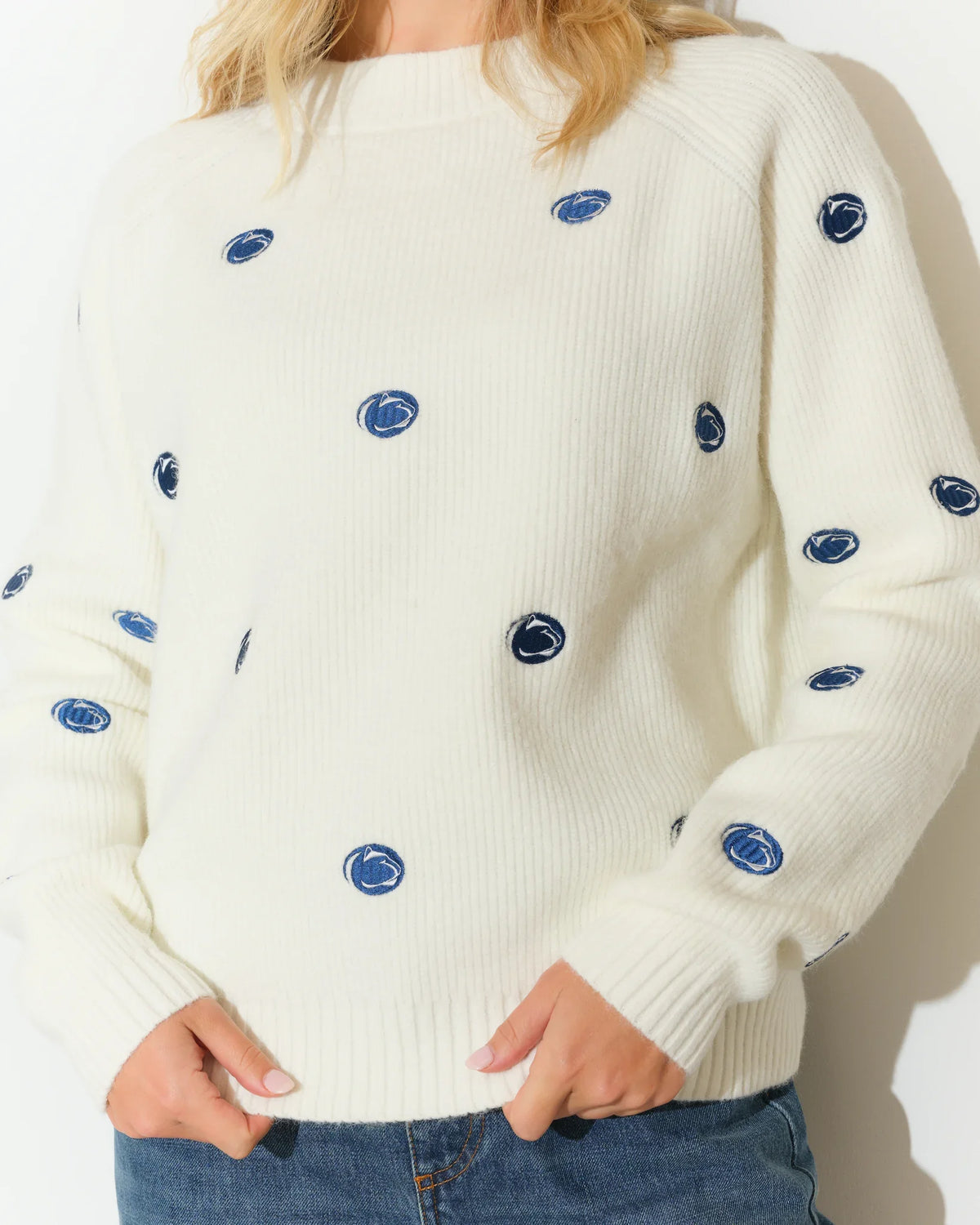 Ivory Penn State Nittany Lions fisherman sweater featuring an allover embroidered lion head logo pattern, shown with a cozy crewneck silhouette.