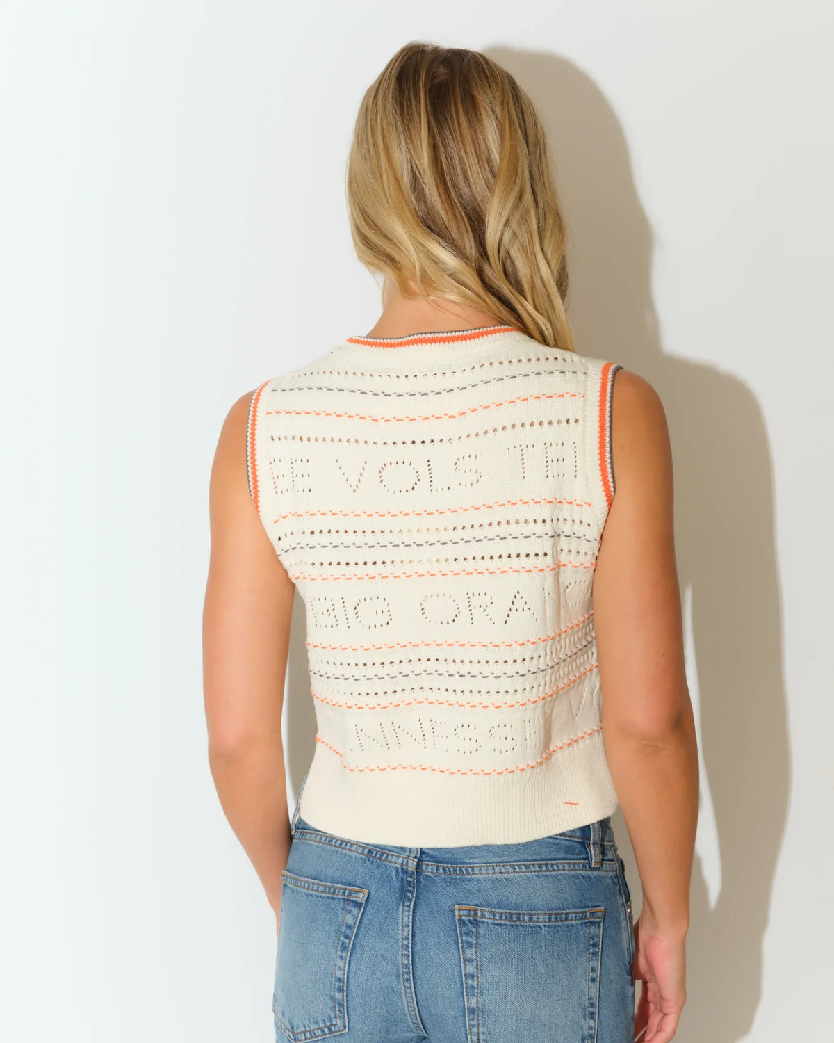 Ivory Tennessee Volunteers cropped sweater vest with open-knit texture and embroidered team lettering, styled with jeans.