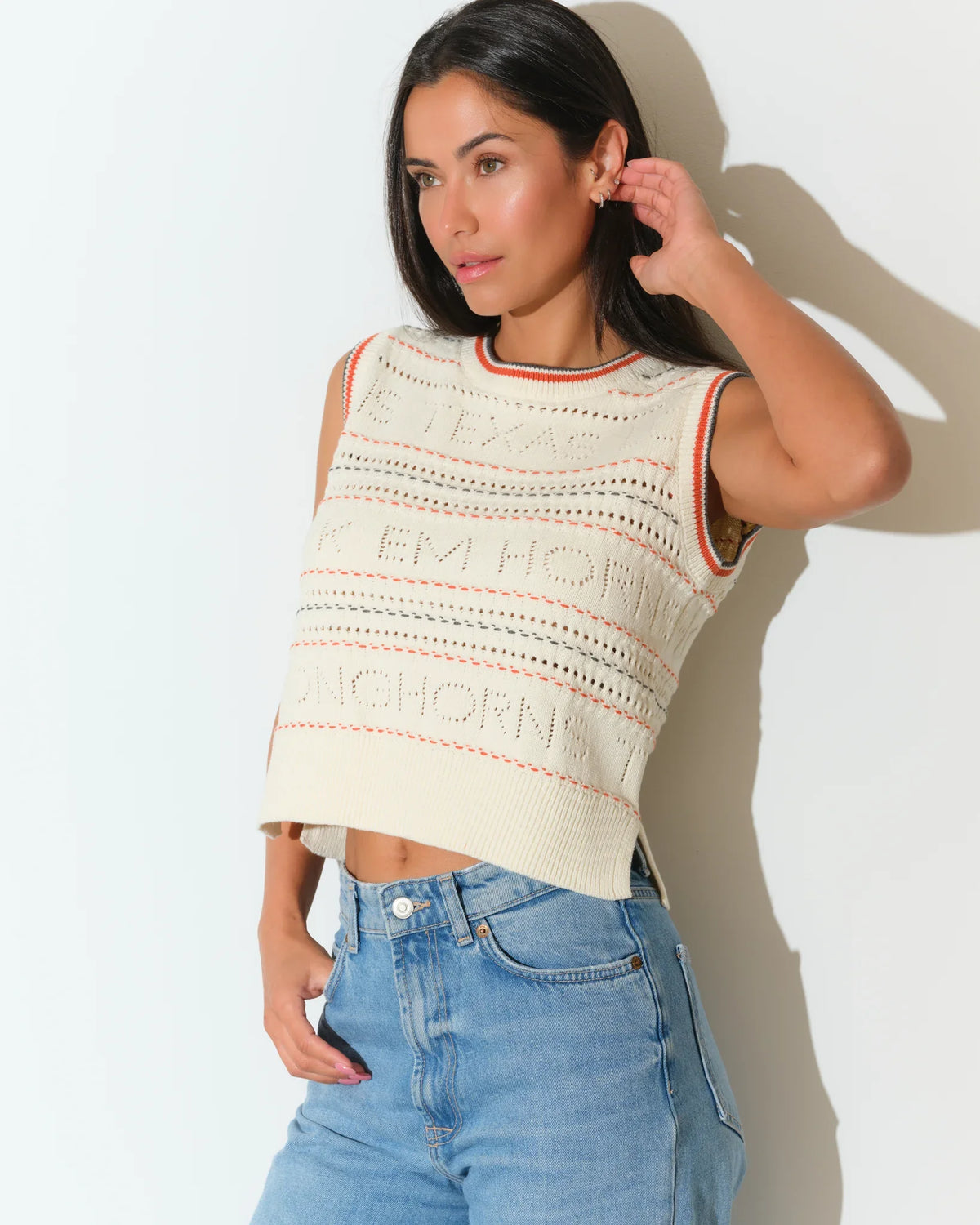 Ivory Texas Longhorns knit sweater vest with textured pattern and striped neckline, styled casually with jeans.