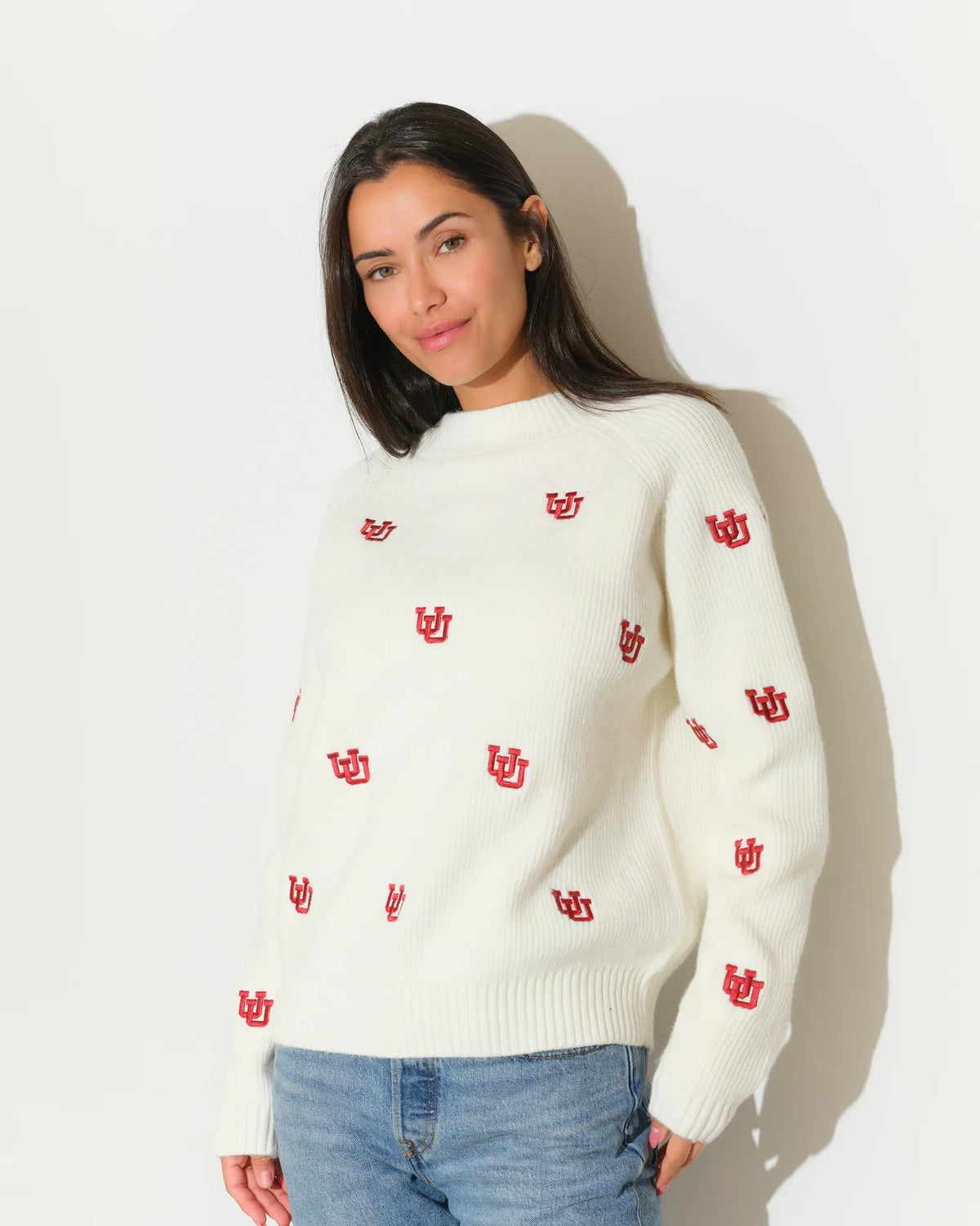 Ivory Utah Utes fisherman sweater with allover red embroidered UU logos, featuring a crew neck and ribbed cuffs.