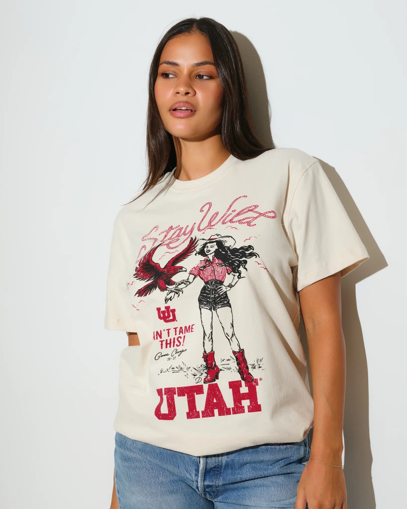 Bone Utah Utes Game Changer Tee featuring a vintage-style graphic of a female figure with crimson "Utah" lettering and a flying bird design.