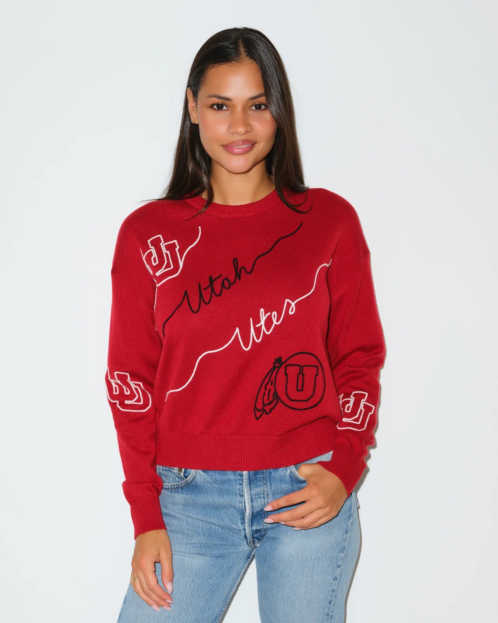 Red Utah Utes crewneck sweater featuring cursive "Utah Utes" script and logo patches on the sleeves and chest.