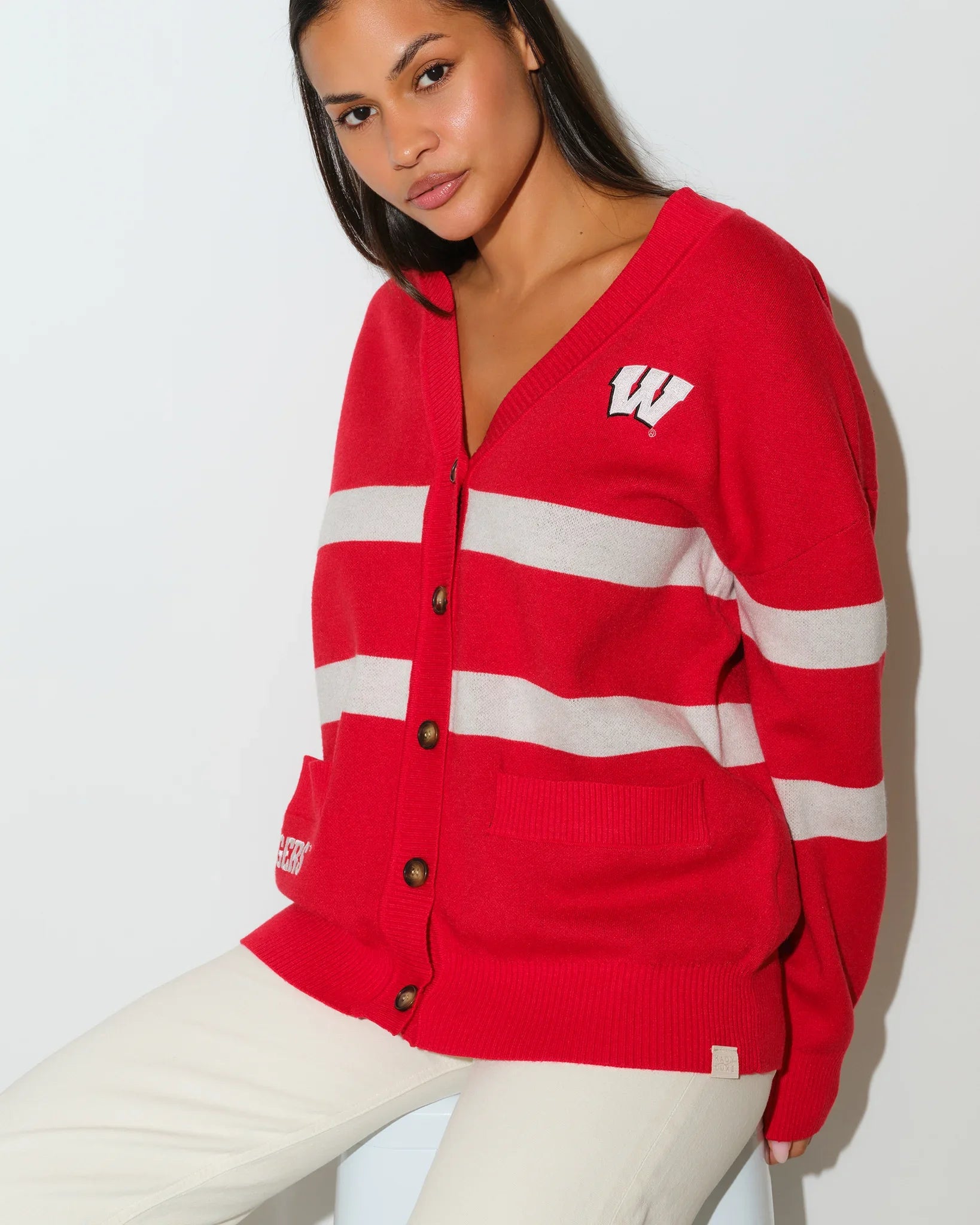 Red Wisconsin Badgers Vinti cardigan with white chest stripes, V-neck, button front, and embroidered "W" logo on the left chest.