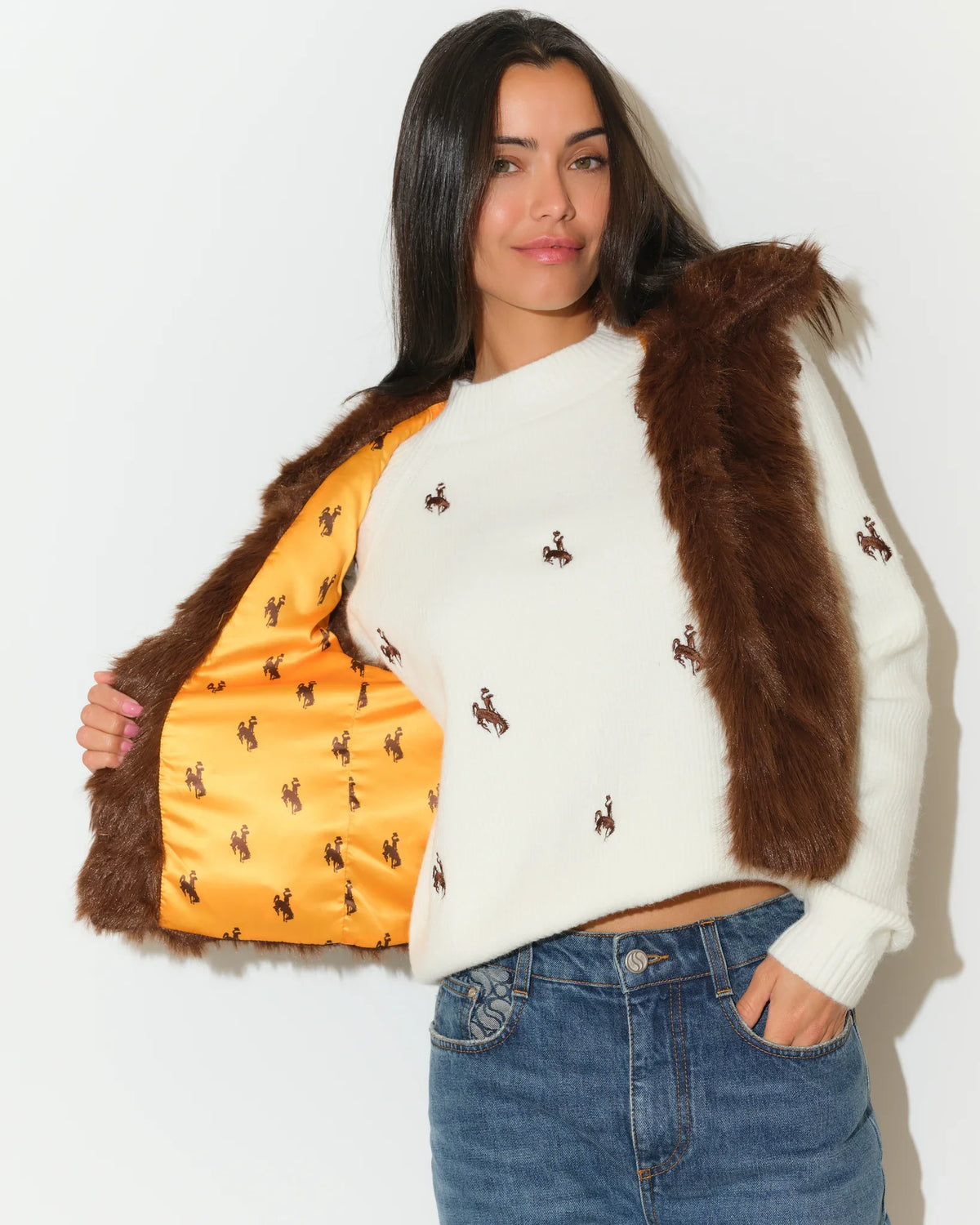 Brown faux fur Wyoming Cowboys vest with gold printed lining, shown open over a white Cowboys-embroidered sweater.