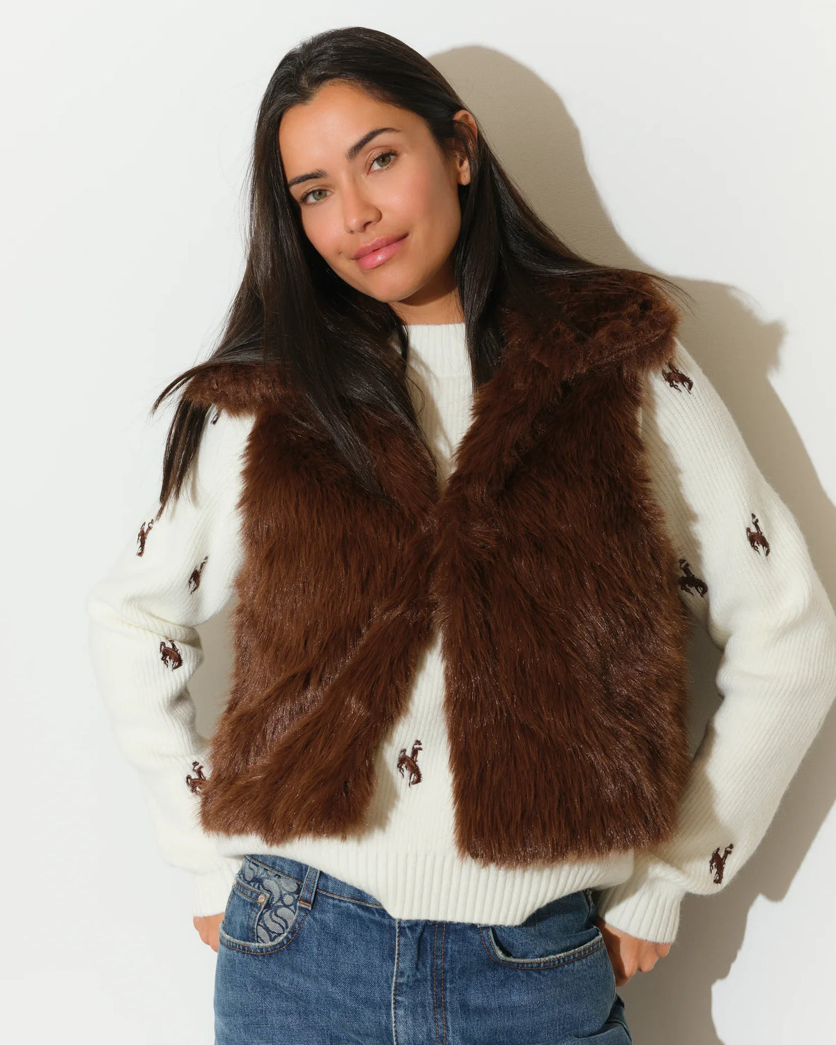 Brown faux fur Wyoming Cowboys vest with gold printed lining, shown open over a white Cowboys-embroidered sweater.