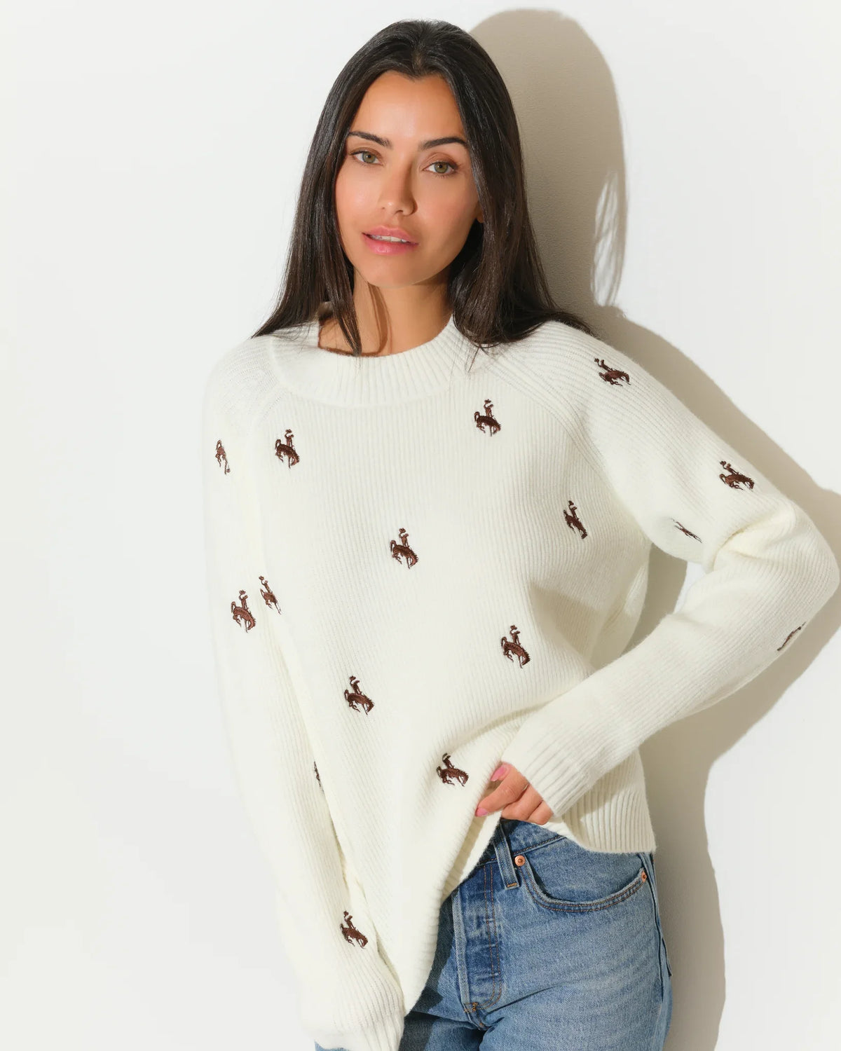 Ivory Wyoming Cowboys fisherman sweater with allover embroidered bucking horse logos, featuring a crew neck and relaxed fit.