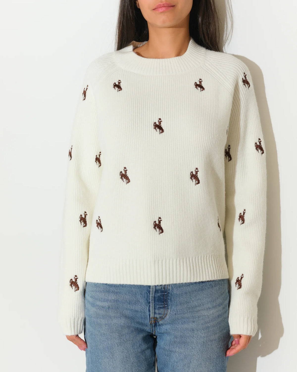 Ivory Wyoming Cowboys fisherman sweater with allover embroidered bucking horse logos, featuring a crew neck and relaxed fit.