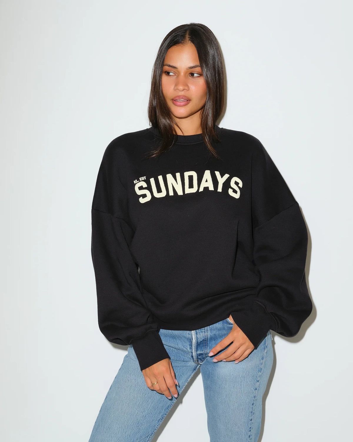 Black KadyLuxe balloon sleeve crew sweatshirt with cream "SUNDAYS" graphic lettering across the chest, featuring oversized dropped shoulders.
