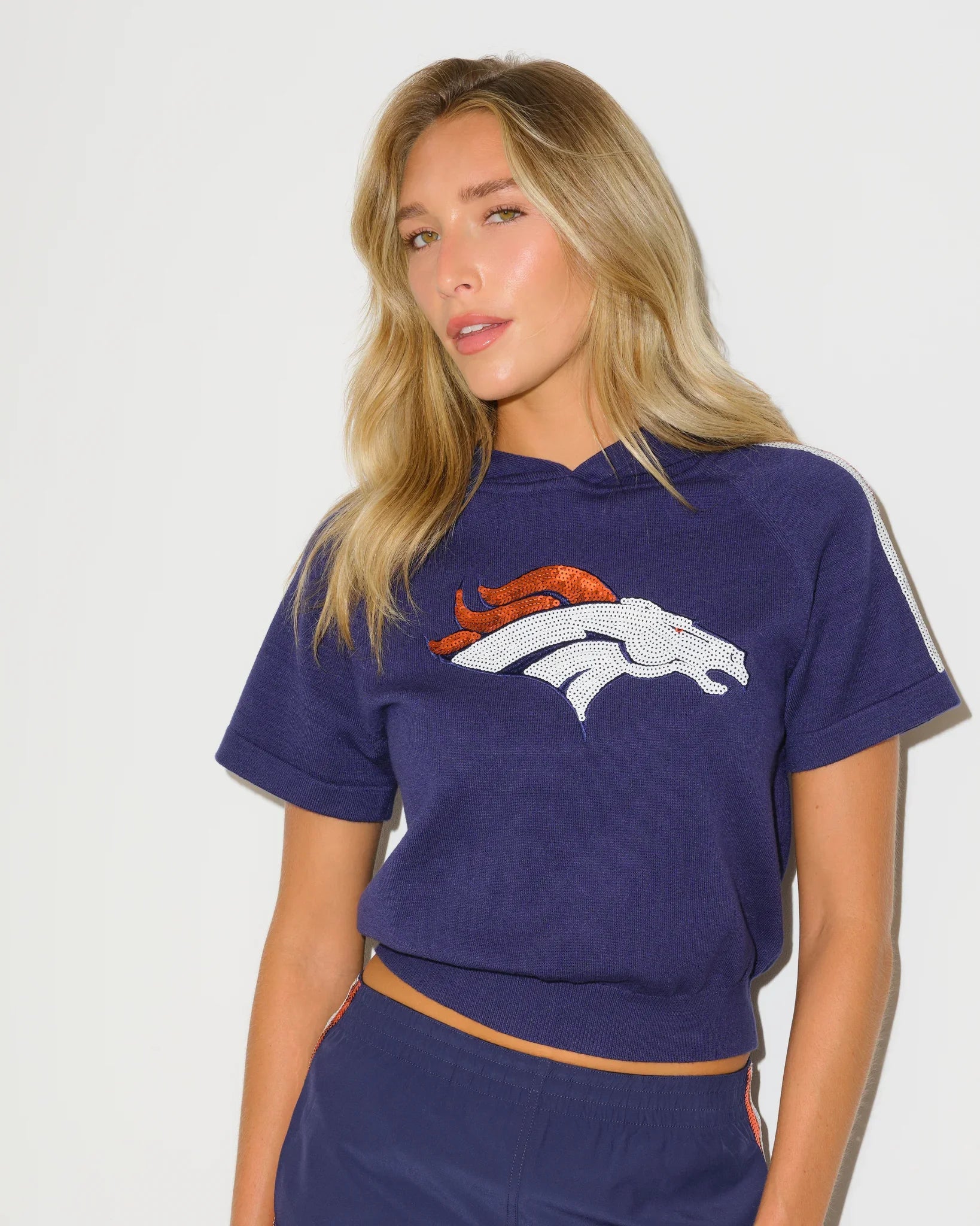 Navy Denver Broncos short sequin knit hoodie, featuring team-licensed detailing with shimmering sequin accents on a cozy knit pullover silhouette.