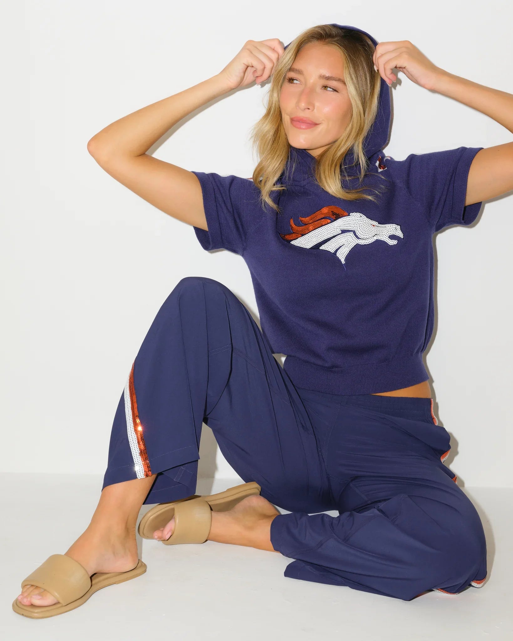 Navy Denver Broncos short sequin knit hoodie, featuring team-licensed detailing with shimmering sequin accents on a cozy knit pullover silhouette.