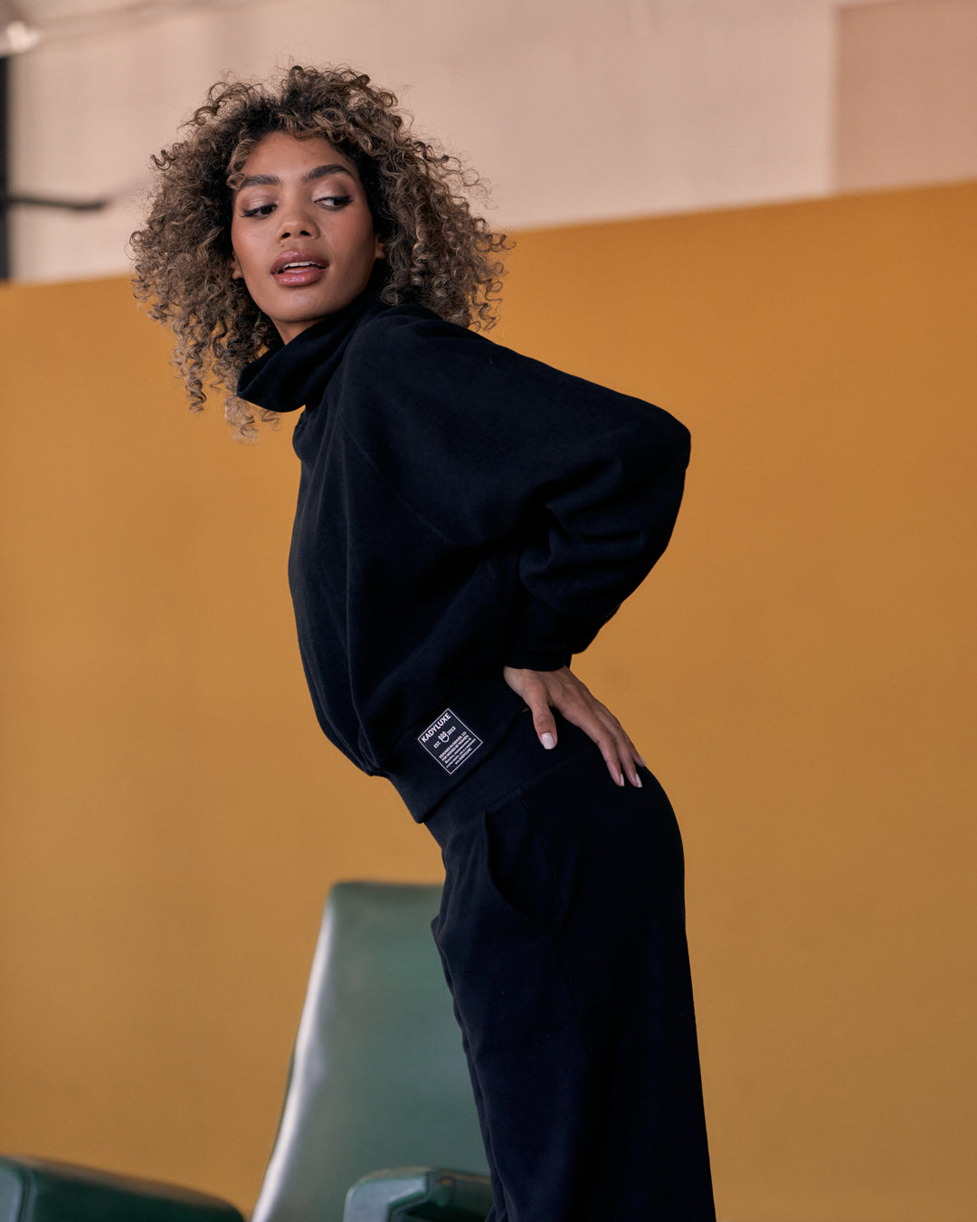 Side view of KADYLUXE® Corduroy Turtleneck Pullover in Black