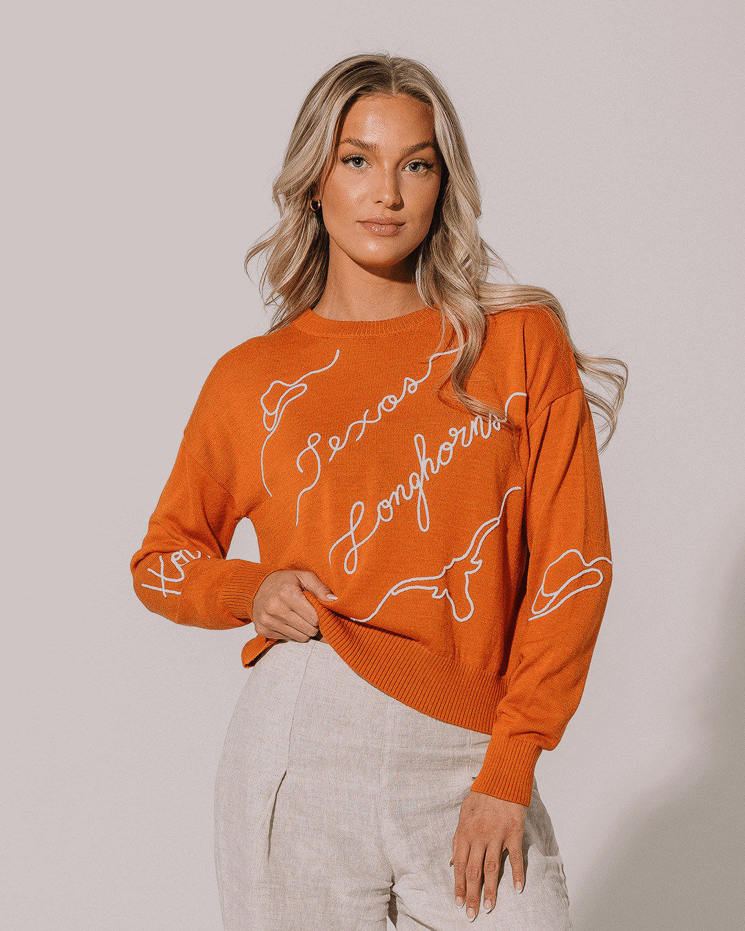 orange long sleeve sweater with texas longhorns embroidery, designed for college tailgate outfits.