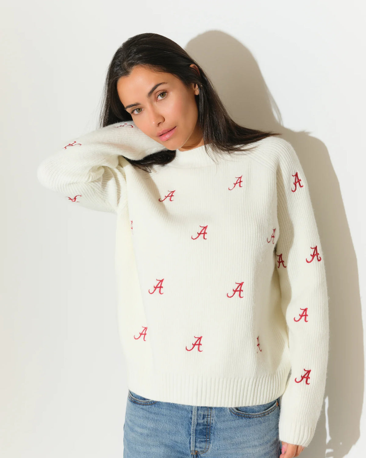 Ivory Alabama Crimson Tide fisherman sweater featuring an allover red "A" logo pattern, shown with a relaxed crewneck fit.