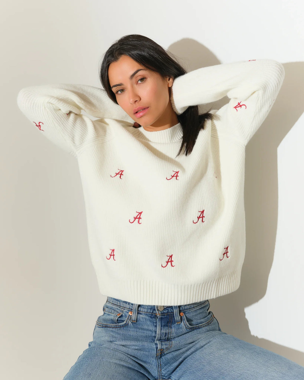 Ivory Alabama Crimson Tide fisherman sweater featuring an allover red "A" logo pattern, shown with a relaxed crewneck fit.