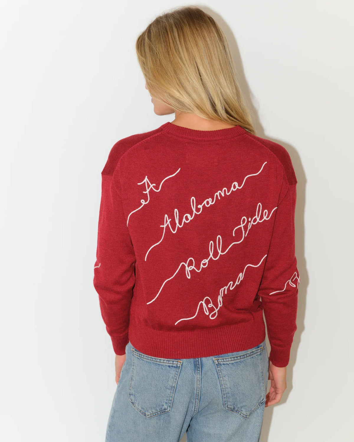 Crimson Alabama Crimson Tide crew neck sweater with cursive "Alabama" script lettering repeated across the front in white.