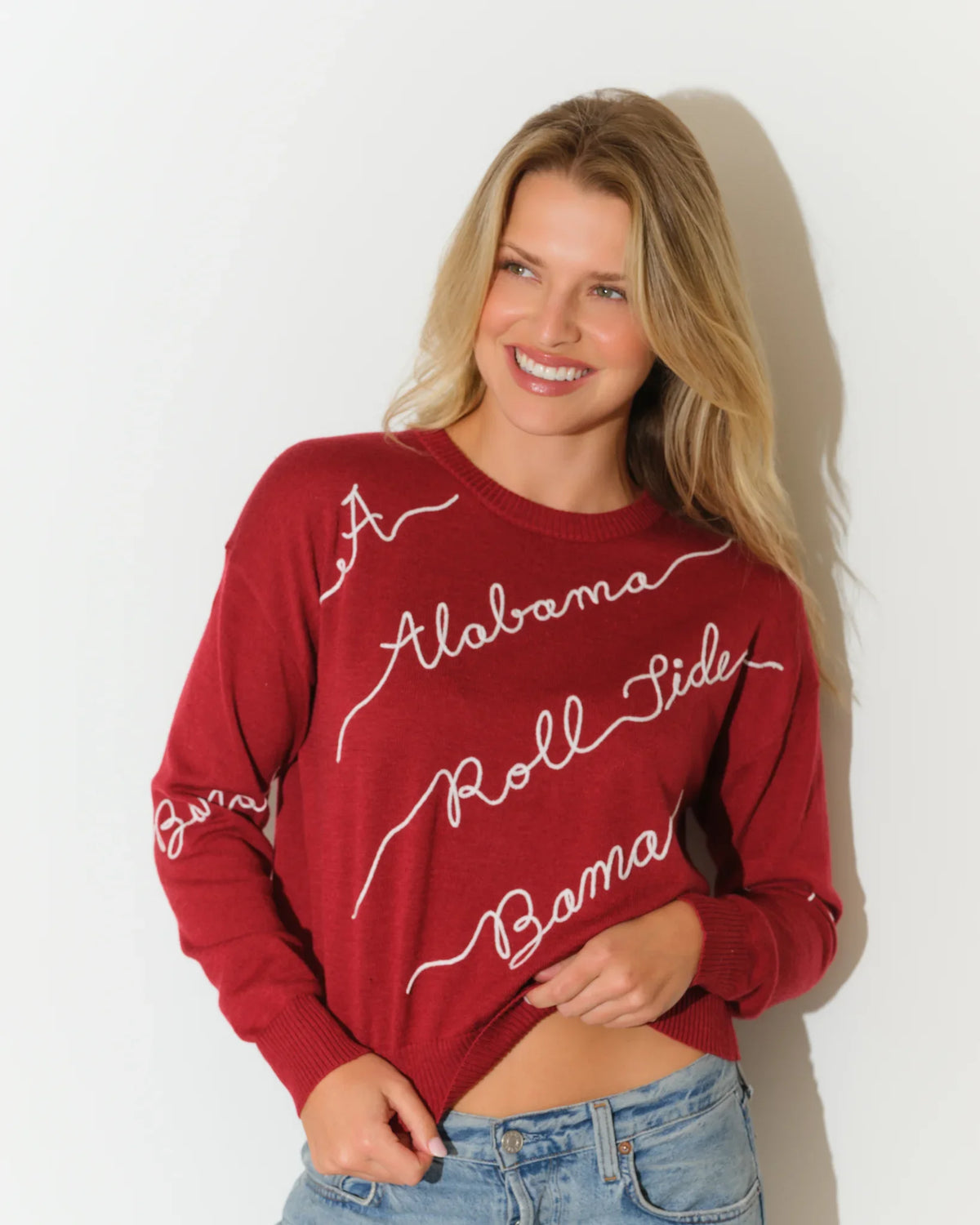 Crimson Alabama Crimson Tide crew neck sweater with cursive "Alabama" script lettering repeated across the front in white.