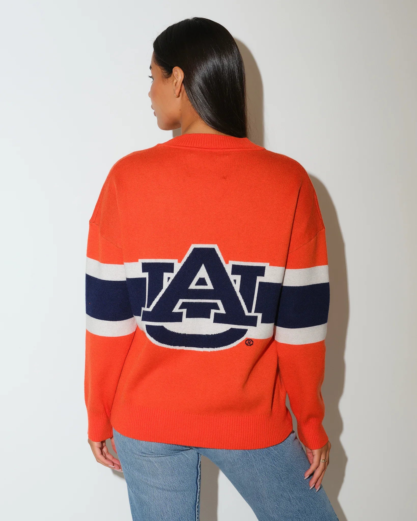 Orange Auburn Tigers Vinti cardigan with navy and white chest stripes, button front, and embroidered logo patch, styled with jeans.