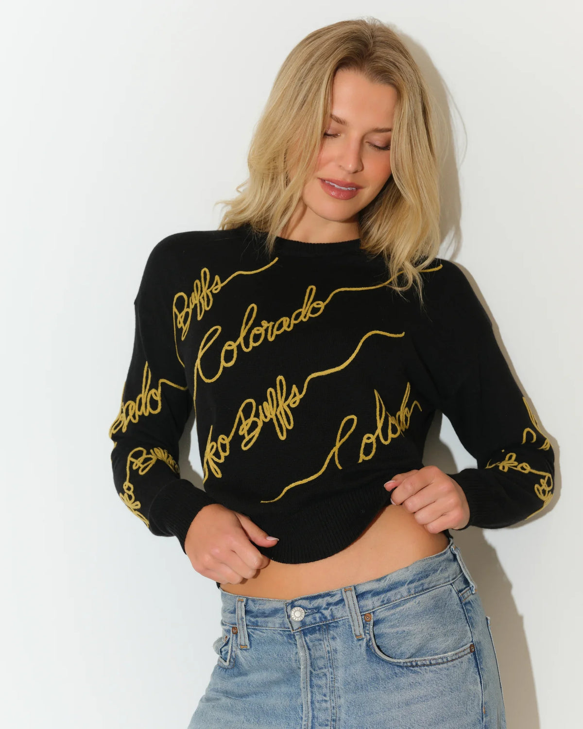 Black Colorado Buffaloes crewneck sweater with gold cursive "Colorado" script repeated across the front and sleeves.