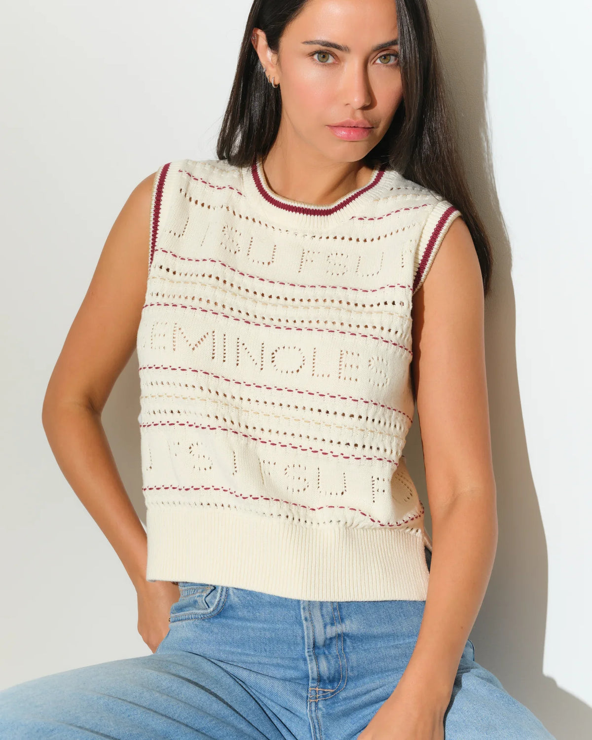 Ivory Florida State Seminoles sweater vest with open-knit pattern and maroon trim, styled with jeans.