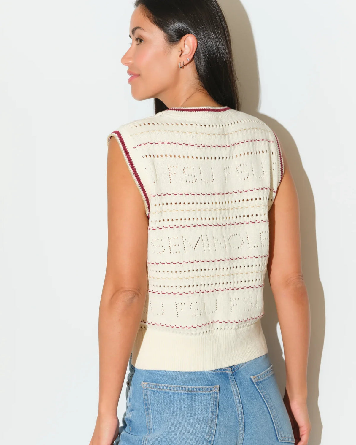 Ivory Florida State Seminoles sweater vest with open-knit pattern and maroon trim, styled with jeans.