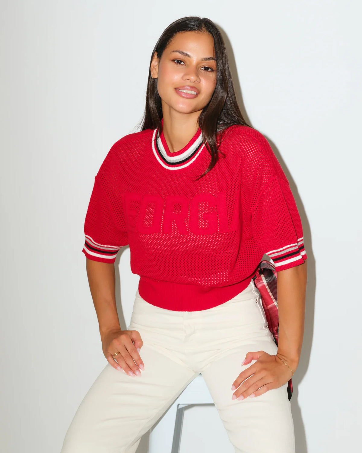 Red Georgia Bulldogs summer sweater with embossed lettering, striped ribbed collar, and short sleeves, styled with white pants.