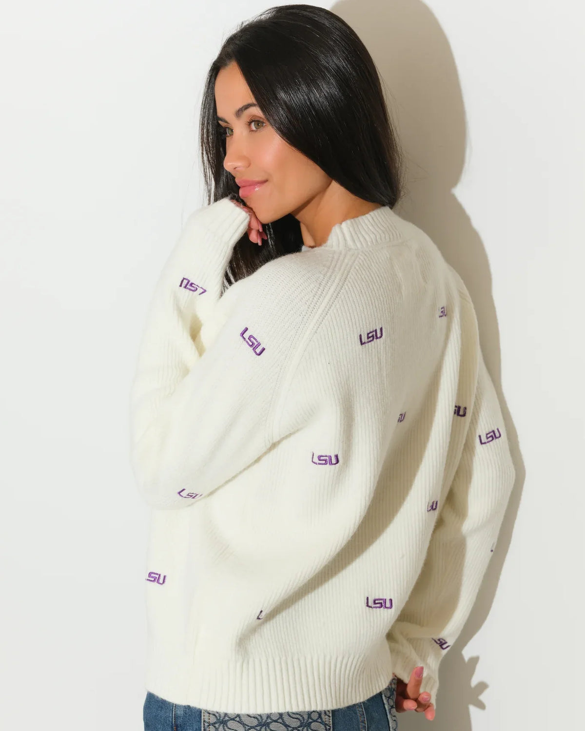 Ivory LSU Tigers fisherman sweater featuring repeated purple "LSU" embroidery throughout, shown on a model with a relaxed crewneck fit.