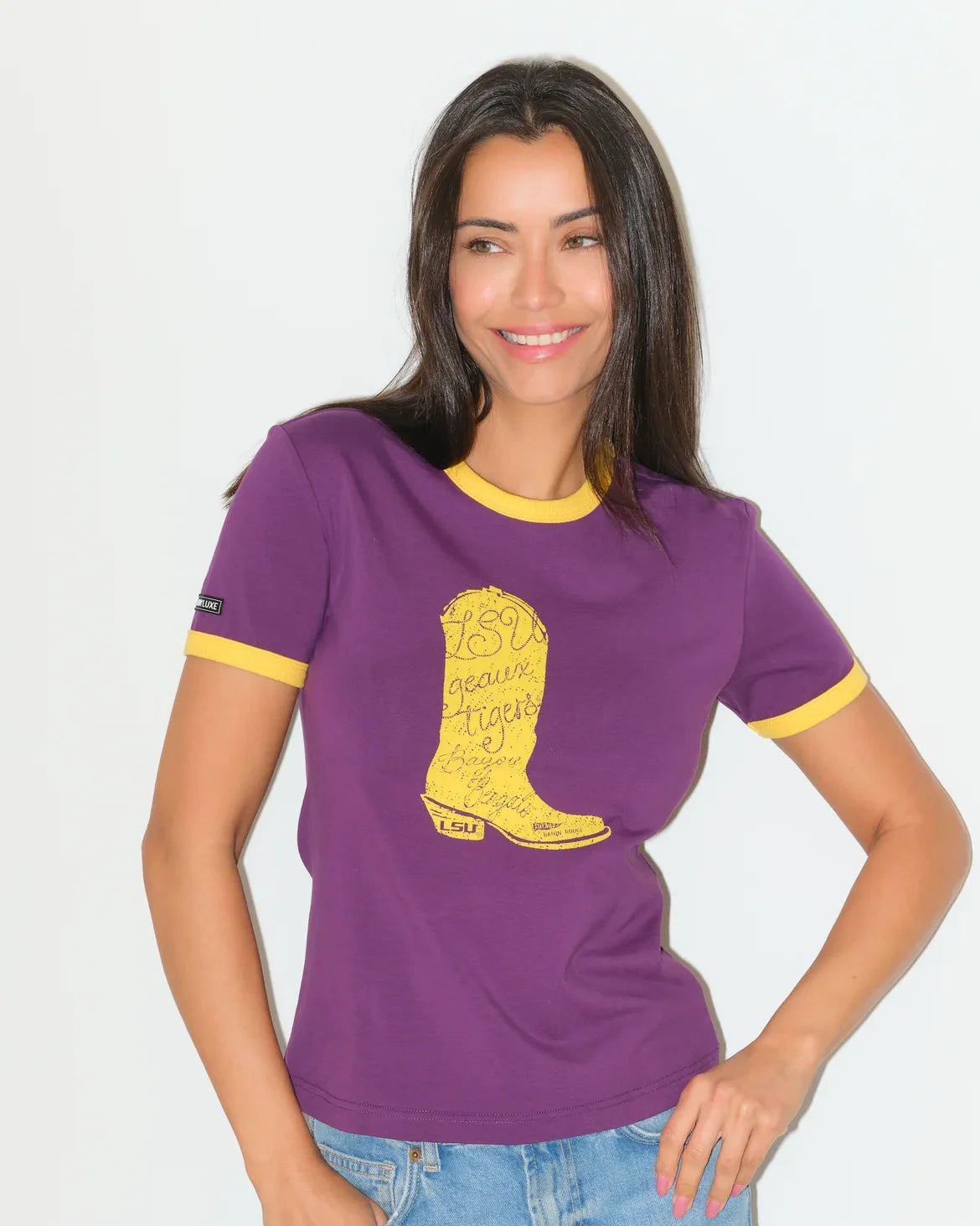 Purple LSU Tigers women's ringer tee with gold trim and a large embroidered-style gold cowboy boot graphic on the chest.