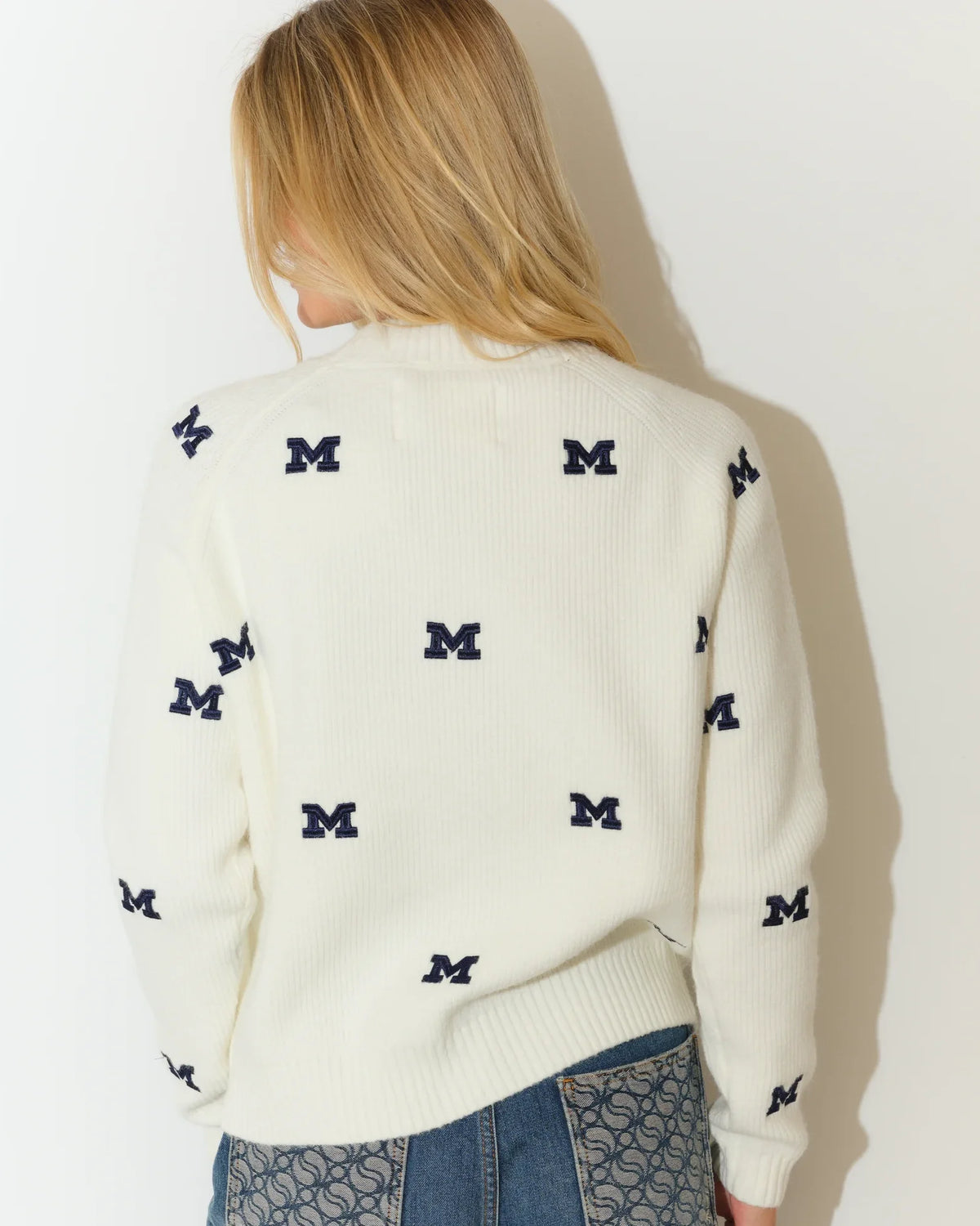 Ivory Michigan Wolverines fisherman sweater featuring an allover navy embroidered "M" logo pattern, with a relaxed crew neck silhouette.