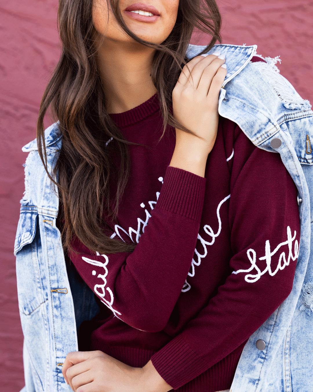 Maroon Mississippi State Bulldogs crew neck sweater with white cursive "Mississippi State" script and decorative wave detailing across the front.