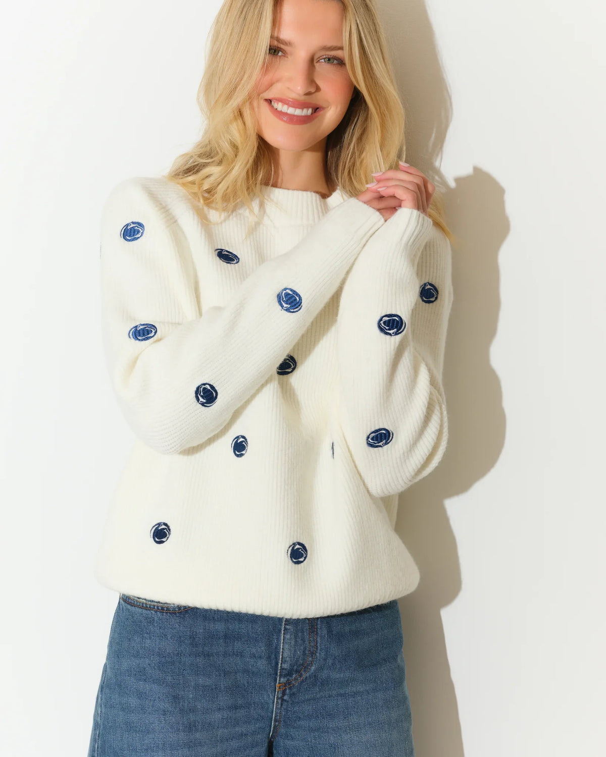Ivory Penn State Nittany Lions fisherman sweater featuring an allover embroidered lion head logo pattern, shown with a cozy crewneck silhouette.