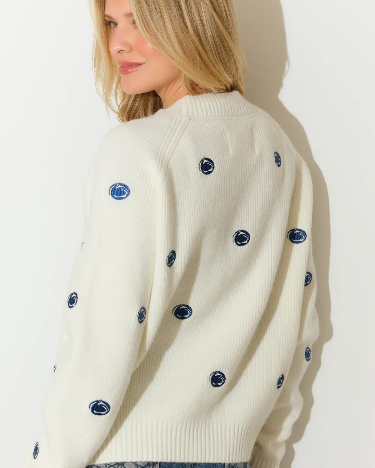 Ivory Penn State Nittany Lions fisherman sweater featuring an allover embroidered lion head logo pattern, shown with a cozy crewneck silhouette.